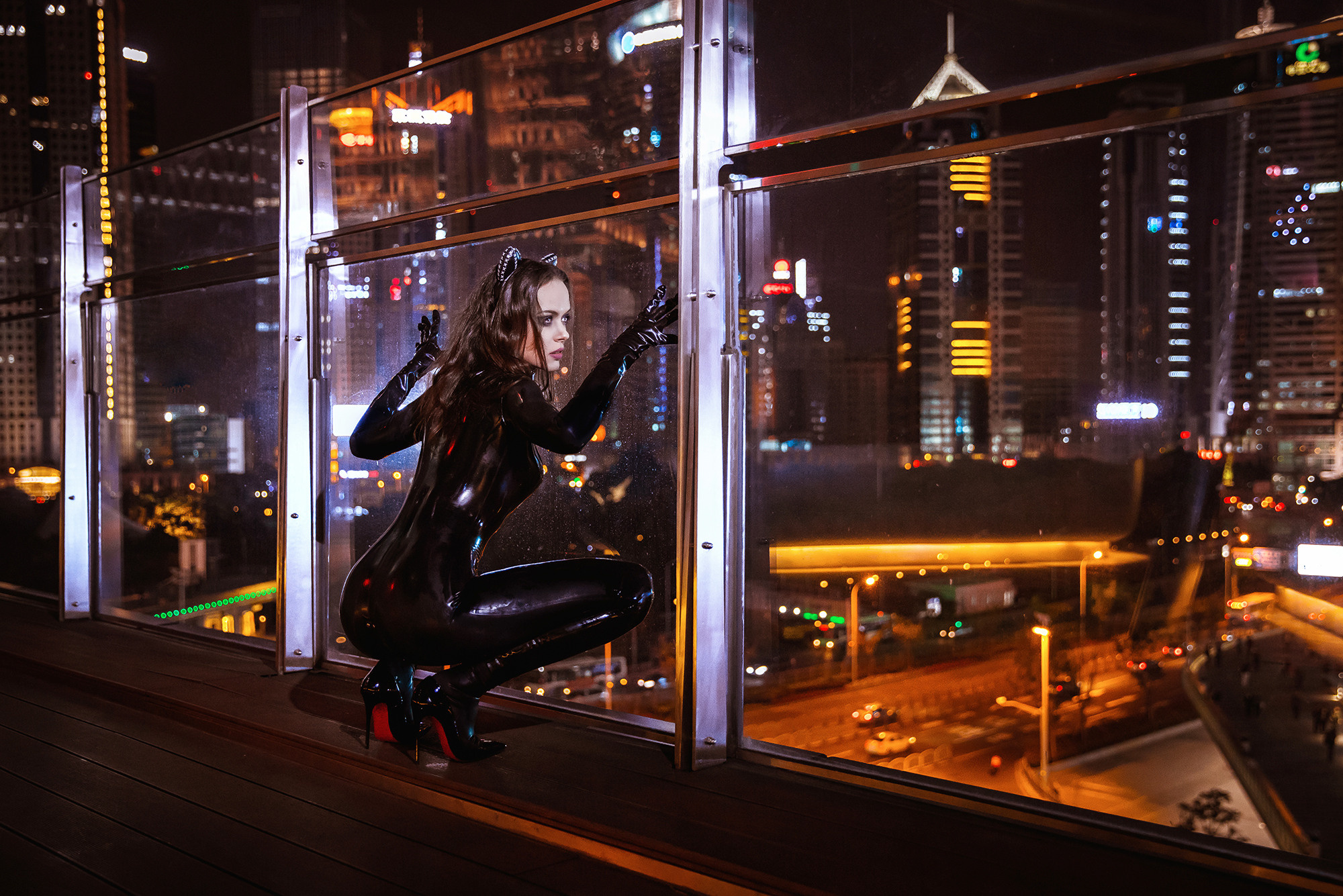 Catwoman. Artistic themed photo shoot in night city, Shanghai. Girl in black latex catwoman costume