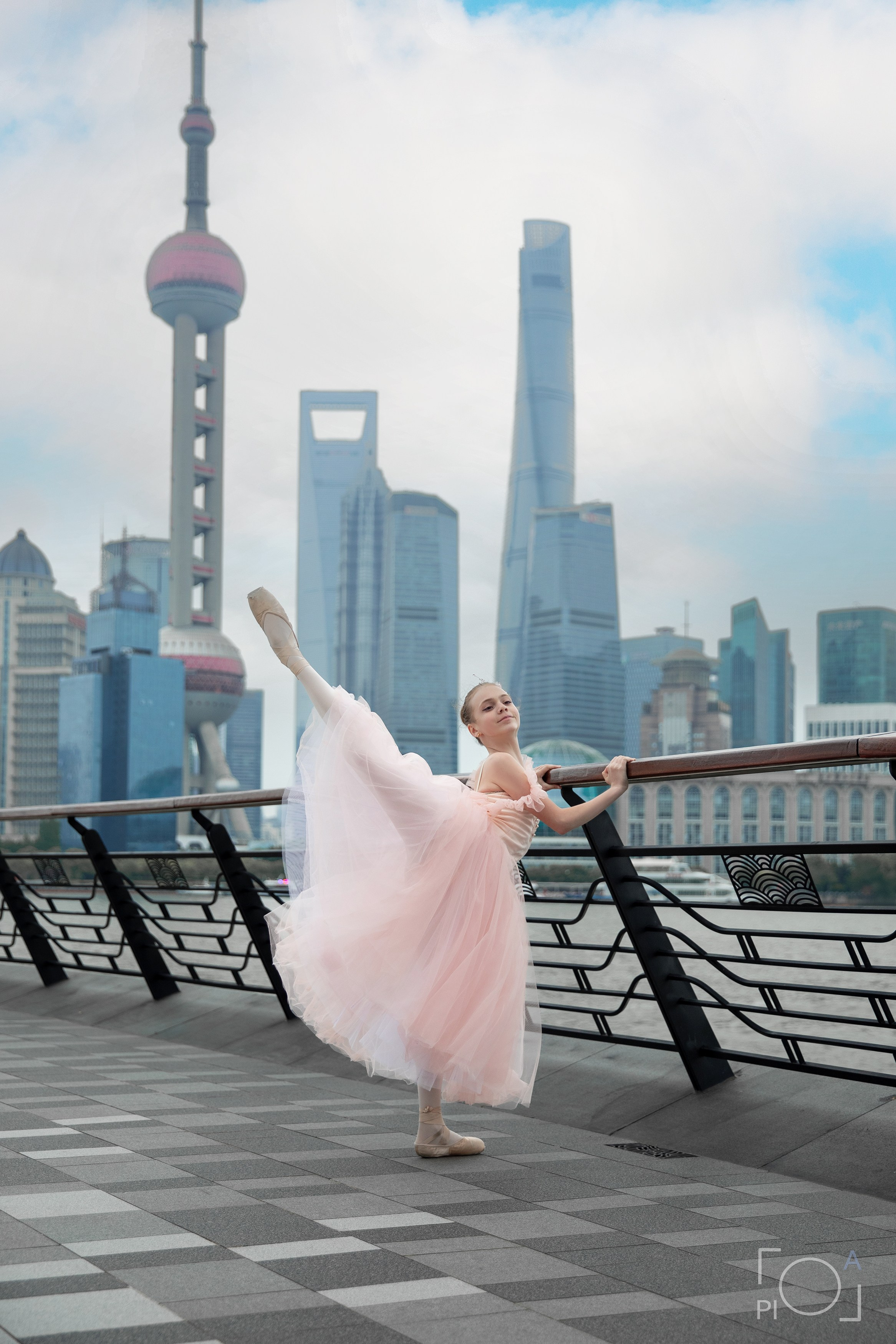 Фотосессия в Шанхае для девочки 11 лет. Маленькая балерина в розовом платье с пышной длинной пачкой, танцует на набережной в Шанхае с видом на Lujiazui