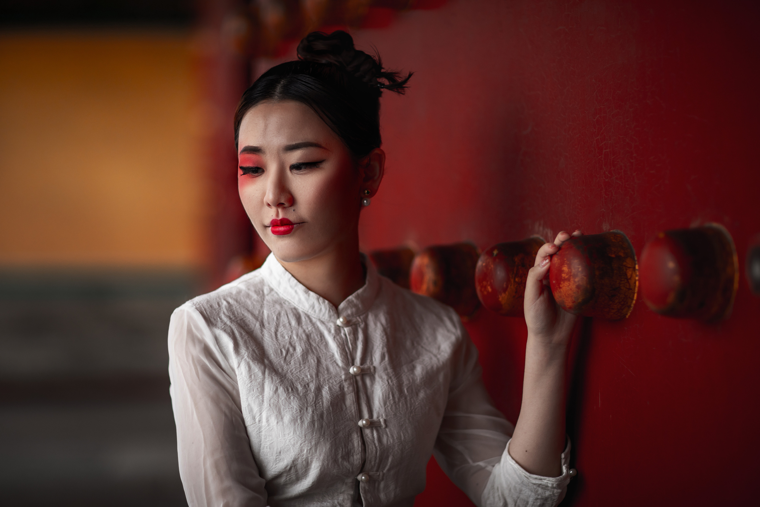Photo shoot in the "forbidden city" in Beijing. Chinese girl with artistic makeup, in white dress