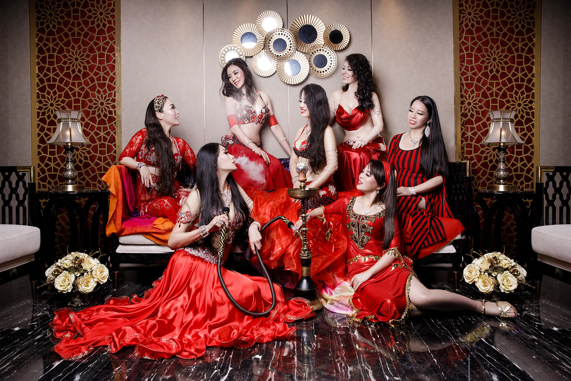 Photo shoot for large group of dancers, belly dancing. Chinese girls in red dresses