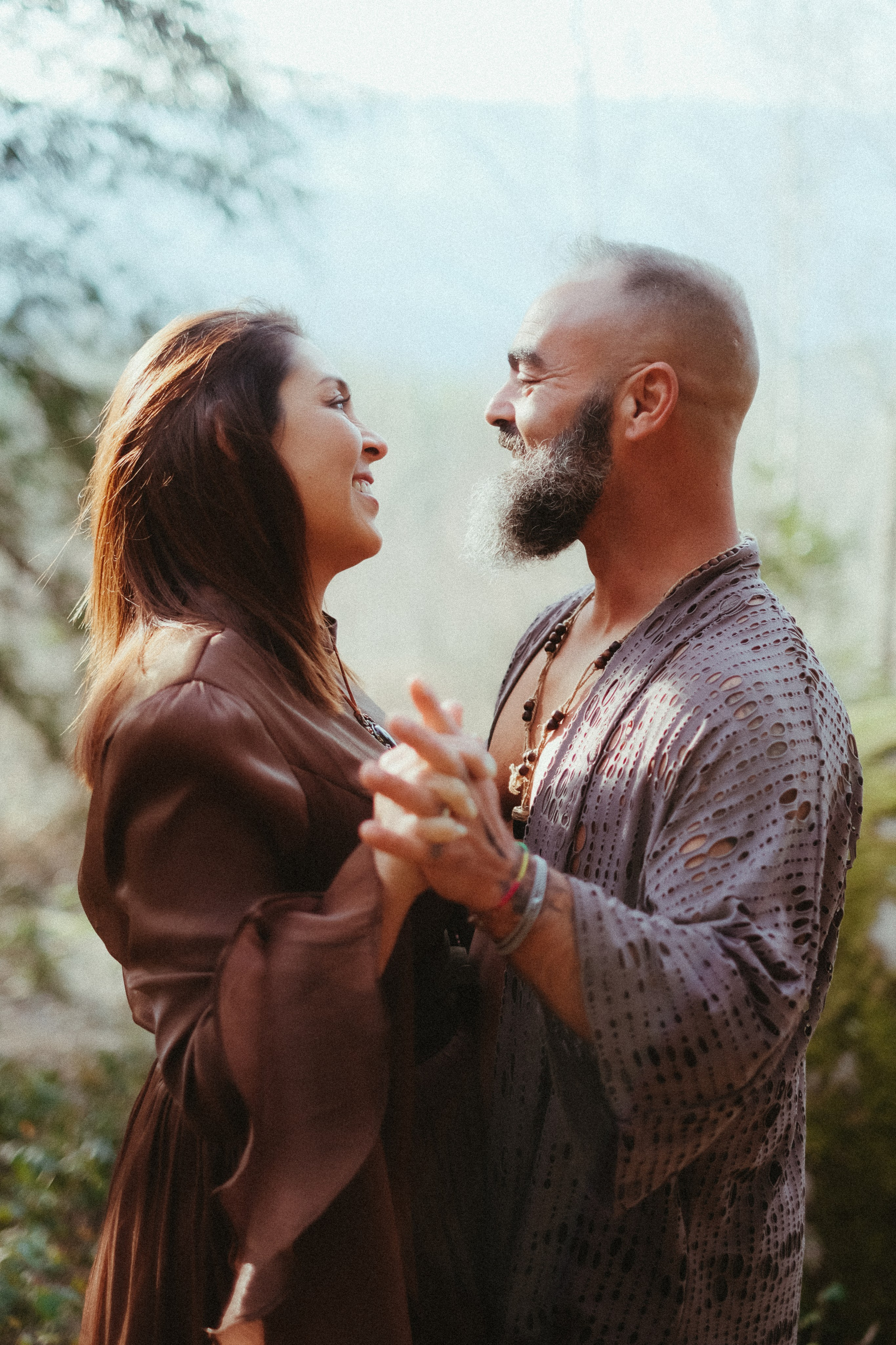 Couple on mossy rock during forest engagement session in Portugal