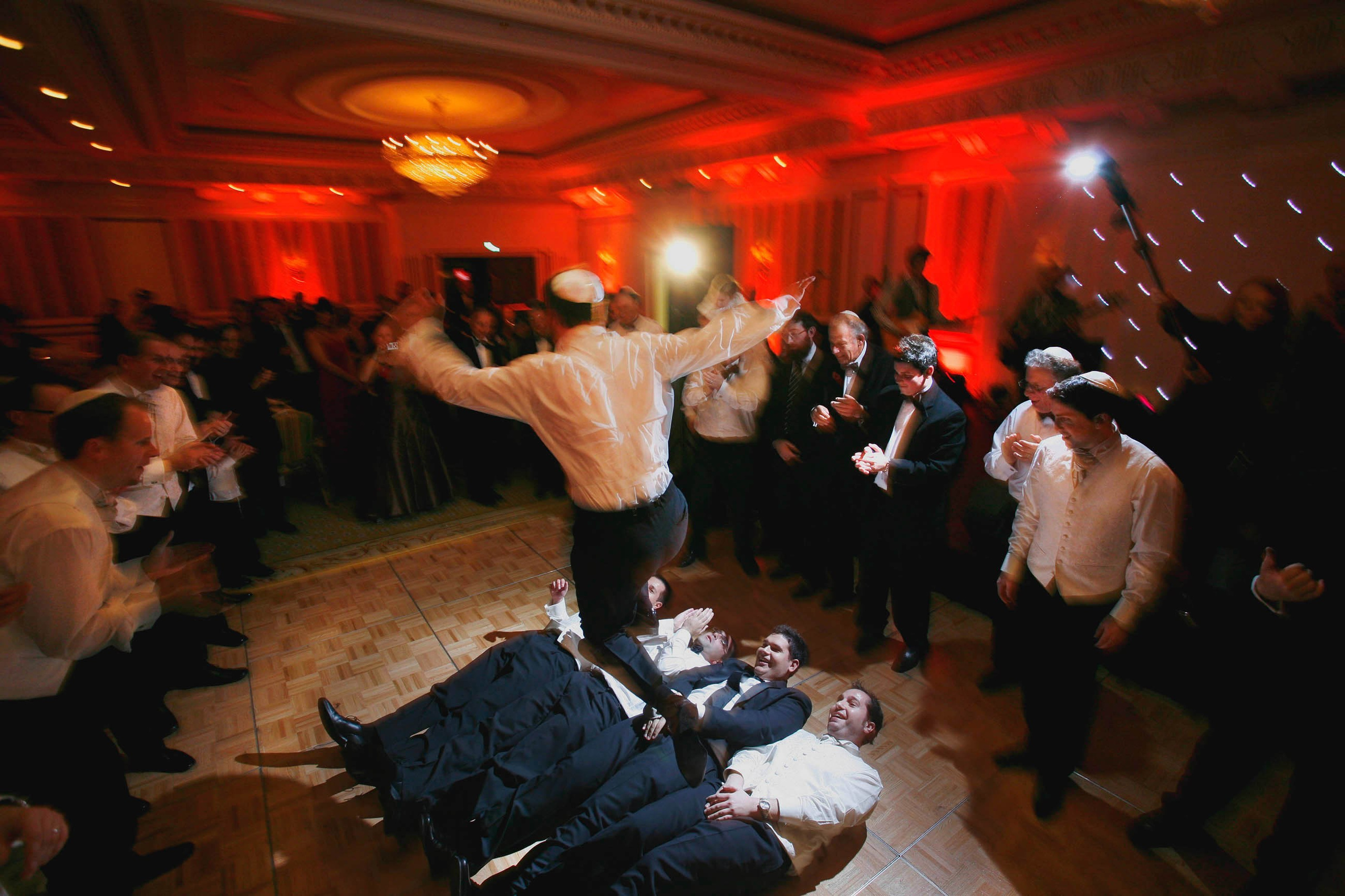 Jewish groom jumps over men during lavish wedding celebration