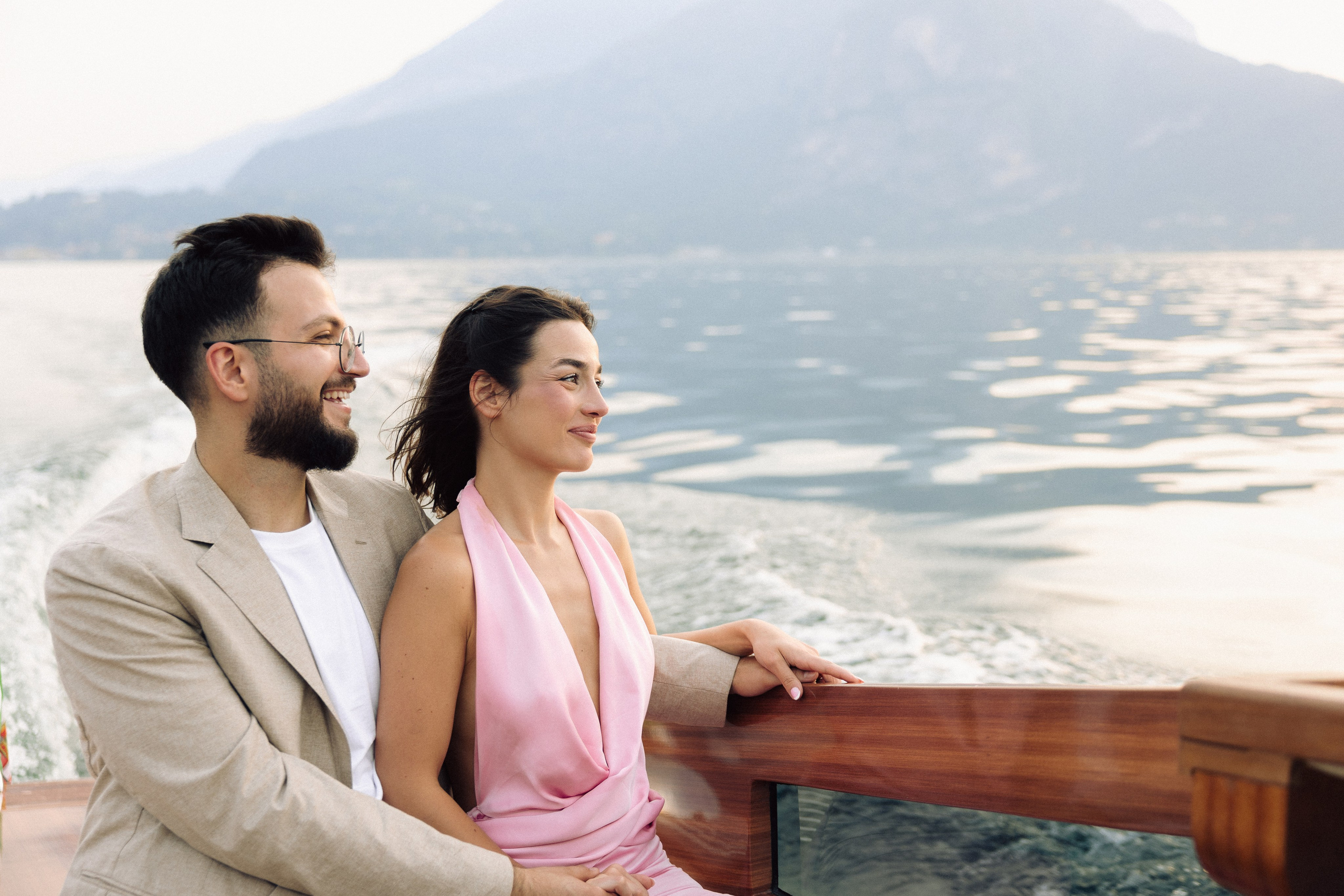 Newly engaged couple enjoying the scenery of Lake Como from a private boat