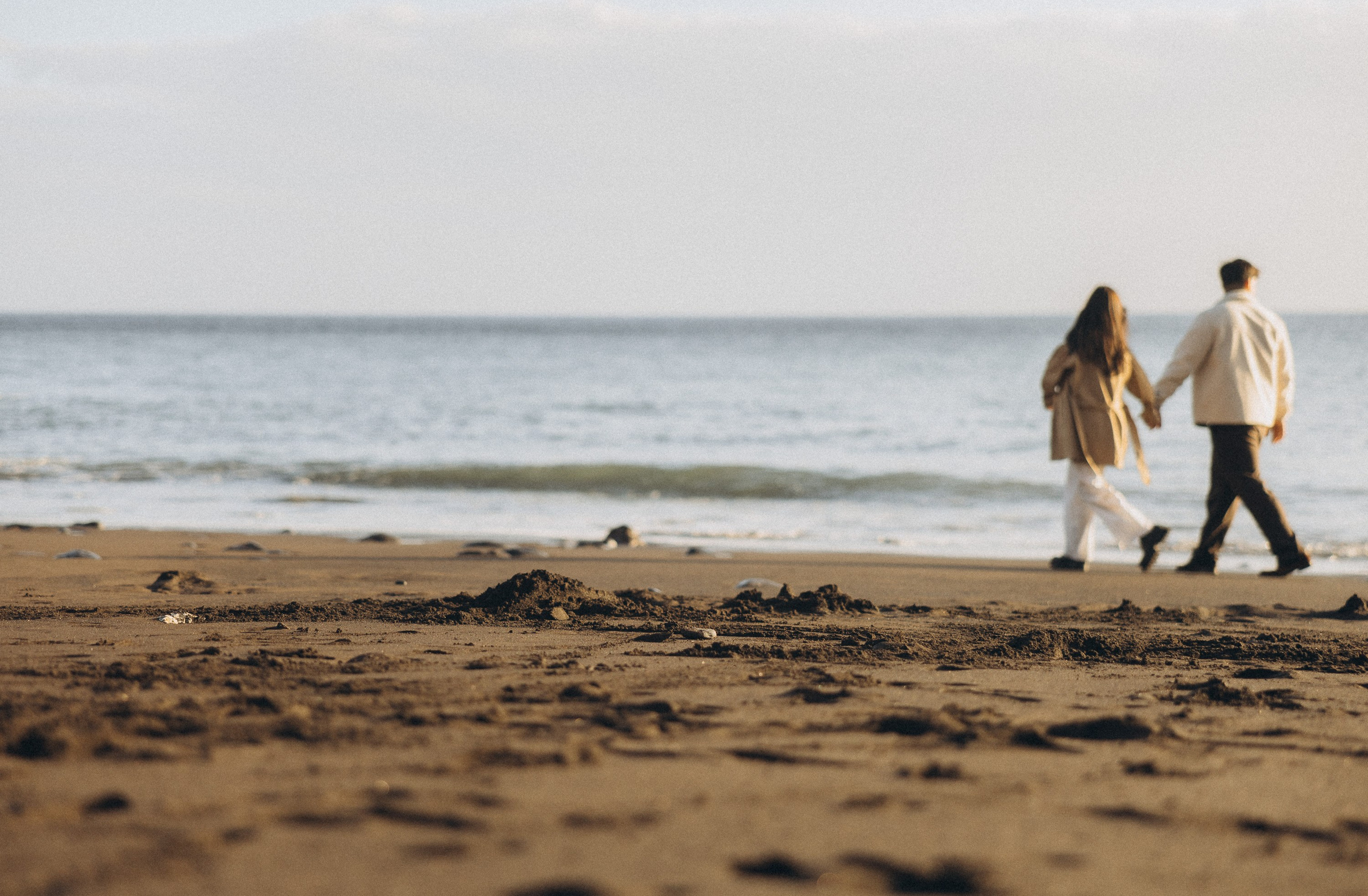 Couple sharing a romantic moment during sunset on Madeira Island, with the ocean and cliffs in the background