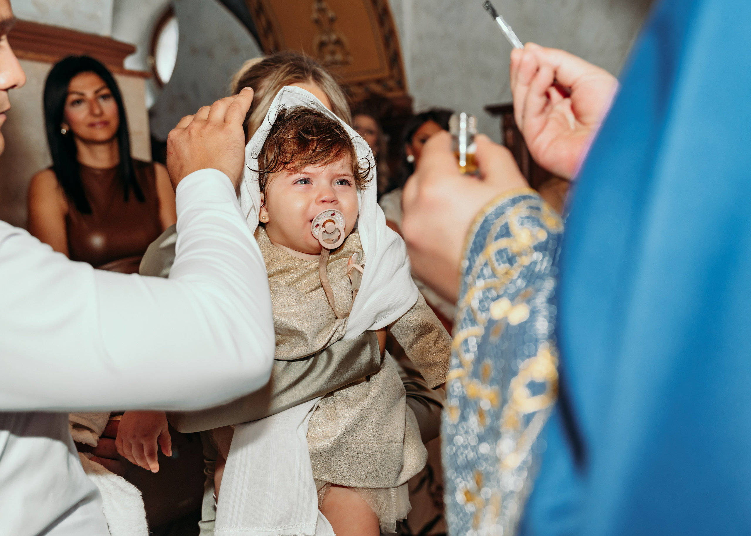 Svestenik pomazuje bebu u crkvi