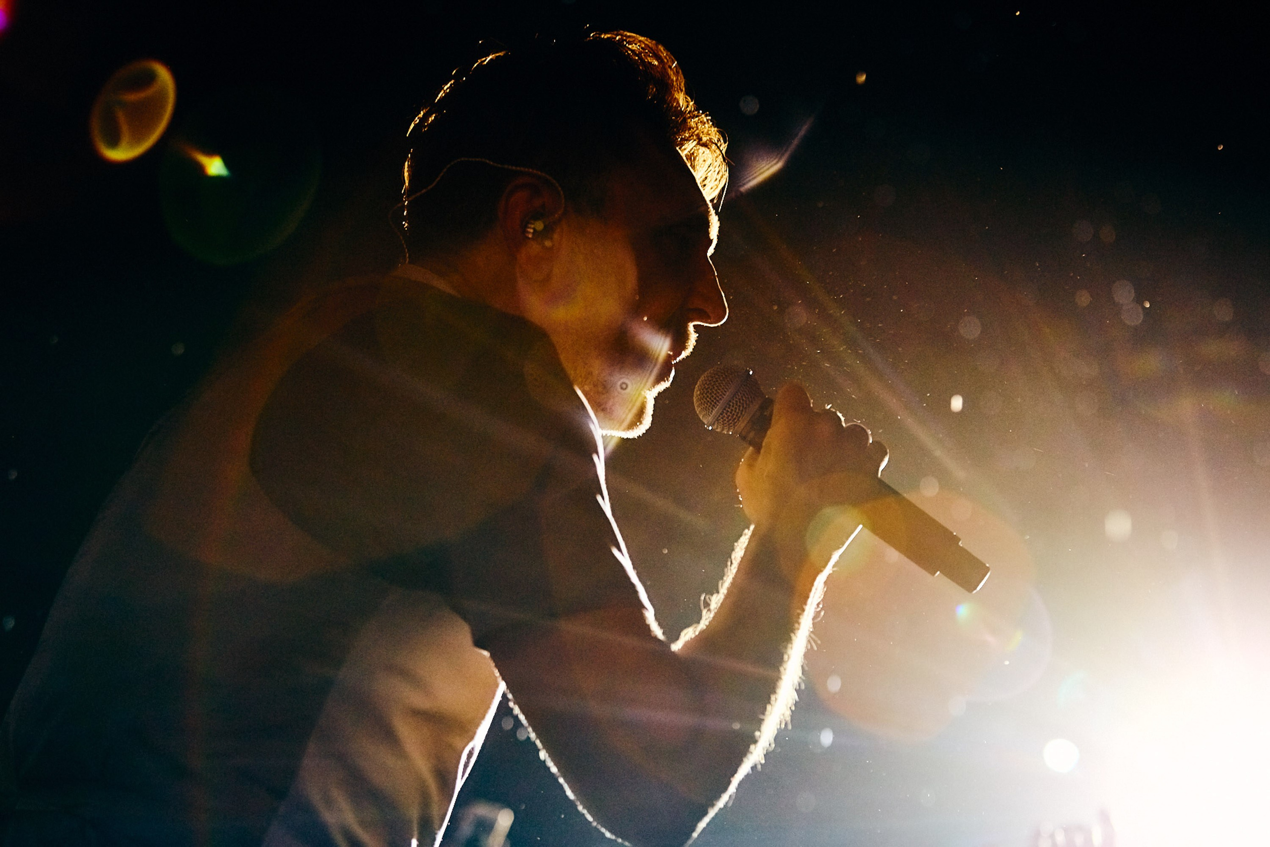 Singer performing on stage with spotlight