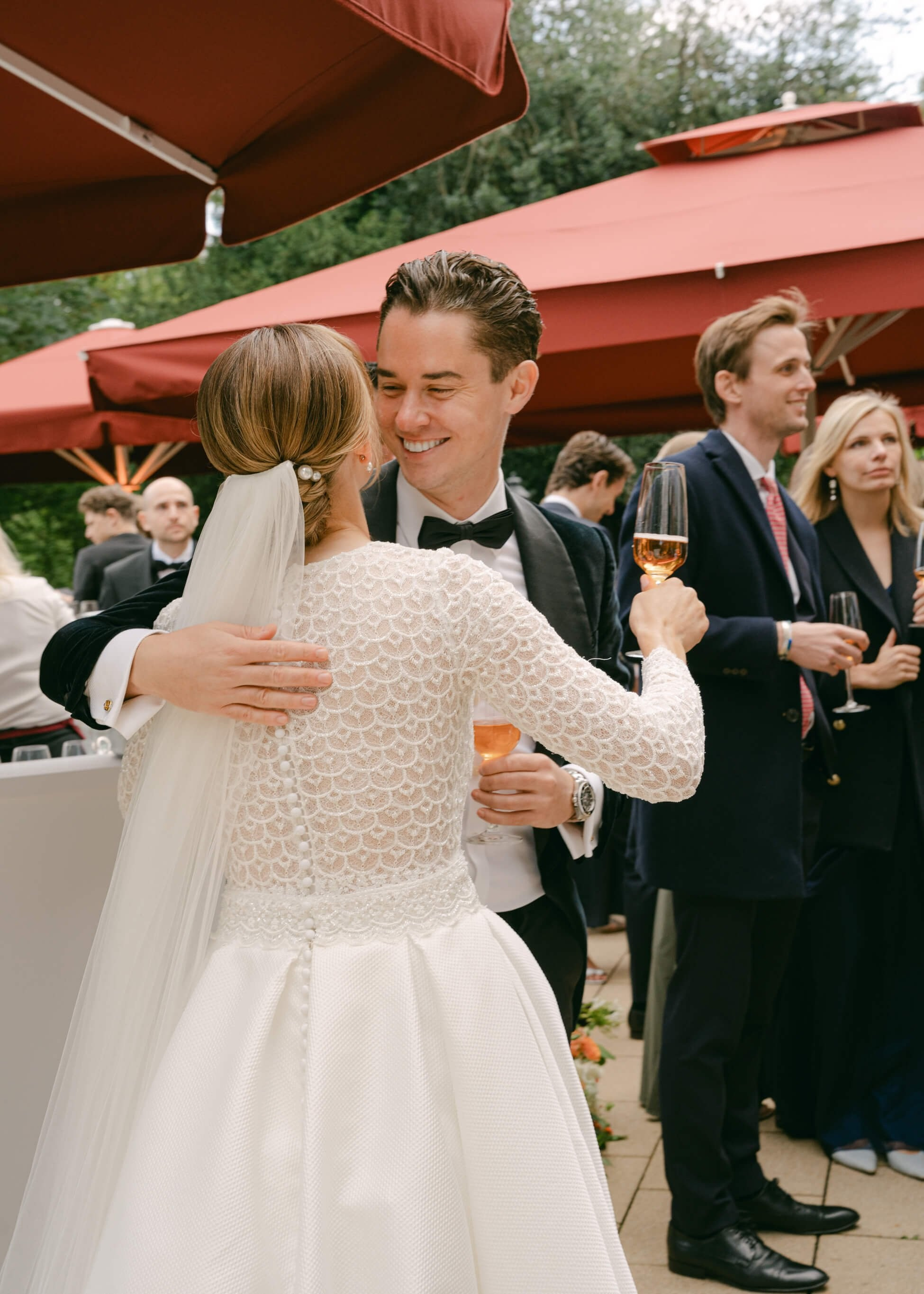 Bride in lace wedding dress with wedding guest at outdoor cocktail reception, luxury wedding Villa Rothschild Frankfurt