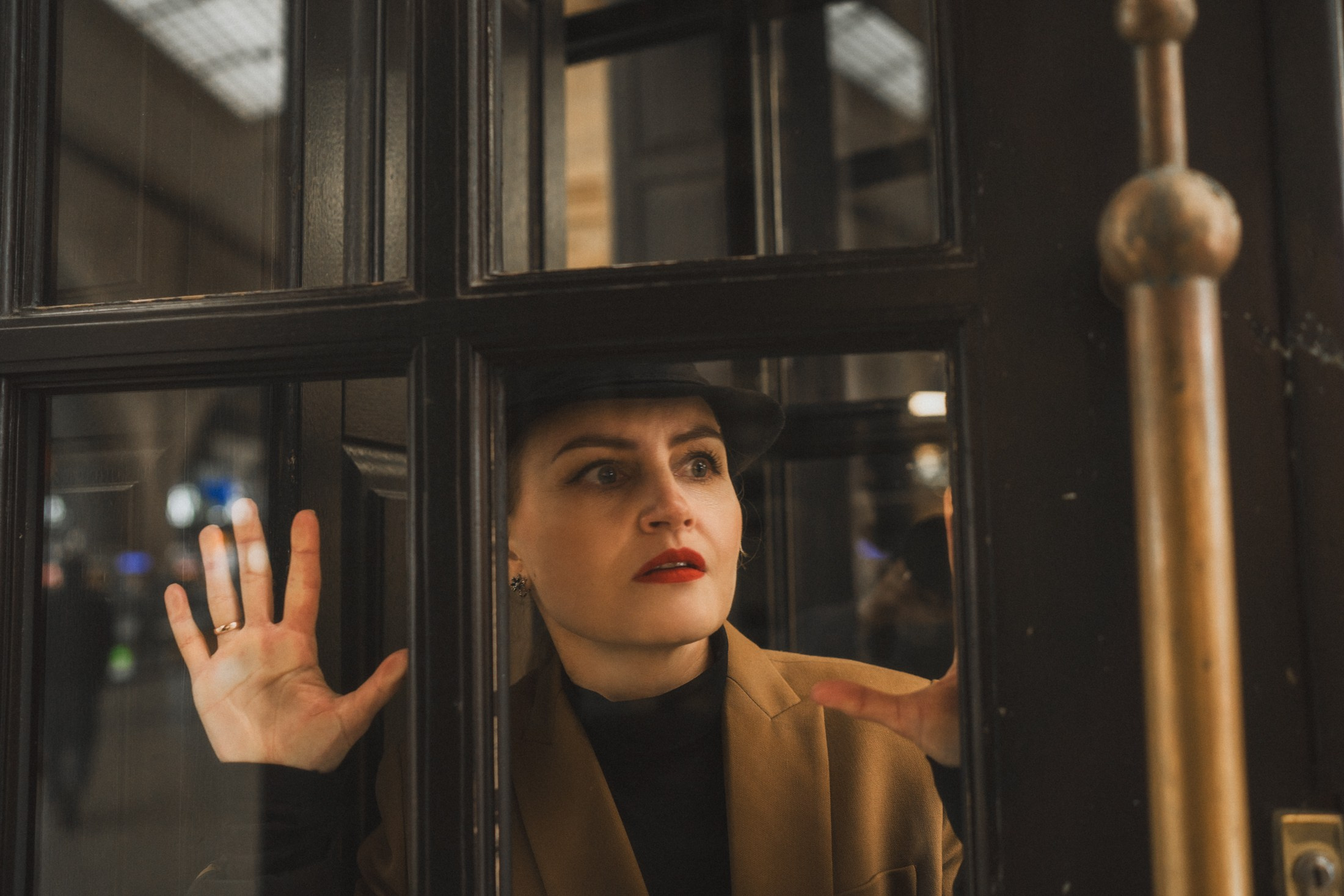 Frau blickt durch das alte Fenster, atmosphärische Bahnhofsszene