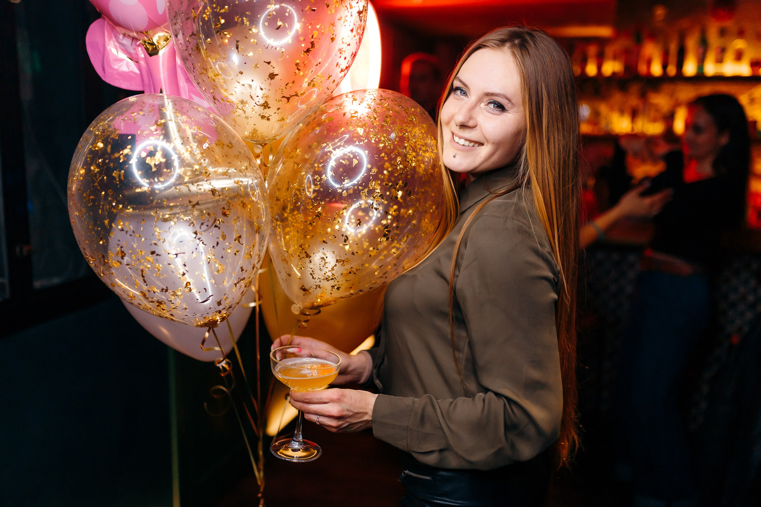 Woman holding light-up balloons at party, festive mood