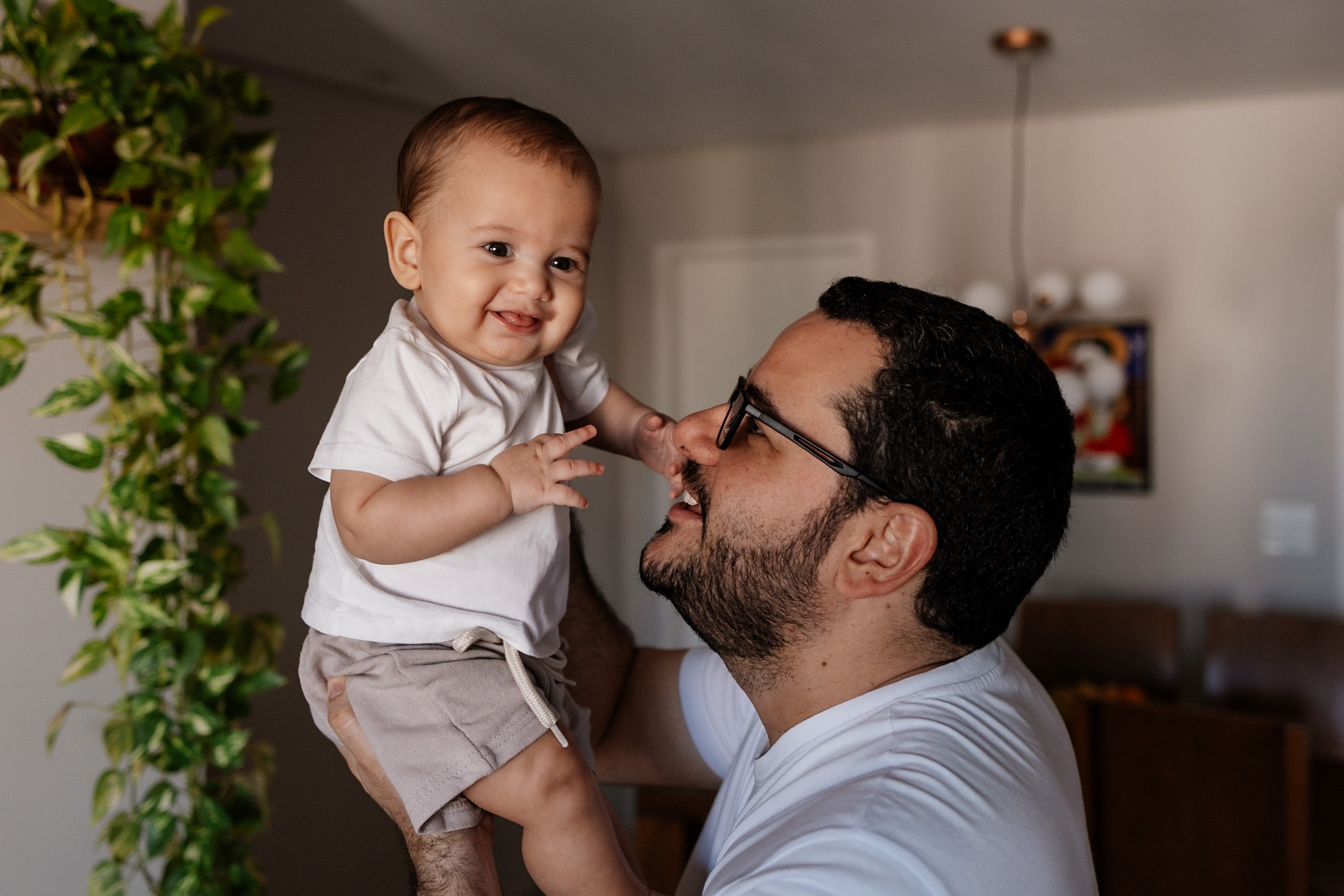 Pai segura o bebê no colo durante ensaio família.