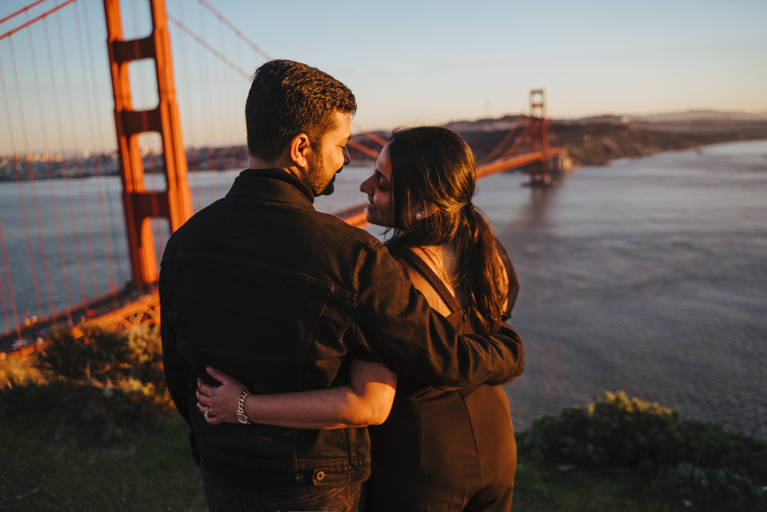 Proposal.  Overlooking the golden San Franisco Bridge sunset with a couple. Photographer Video. 