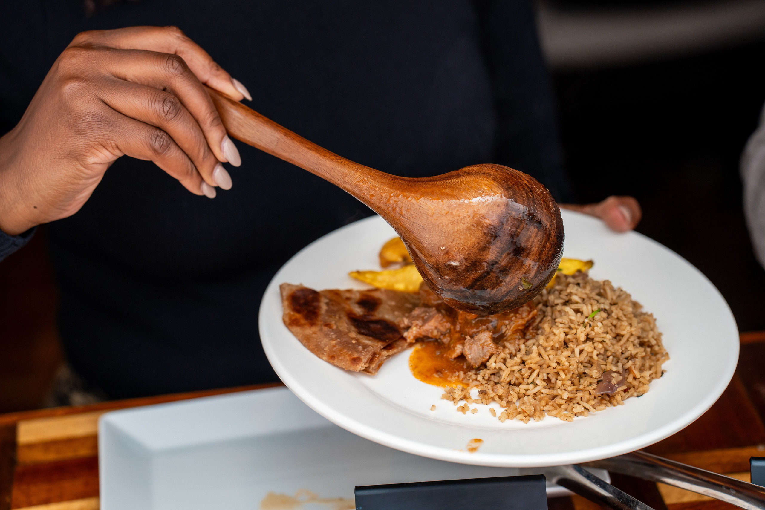 A close-up of a hand serving food at a Nairobi event in Kivulini Eco-park
