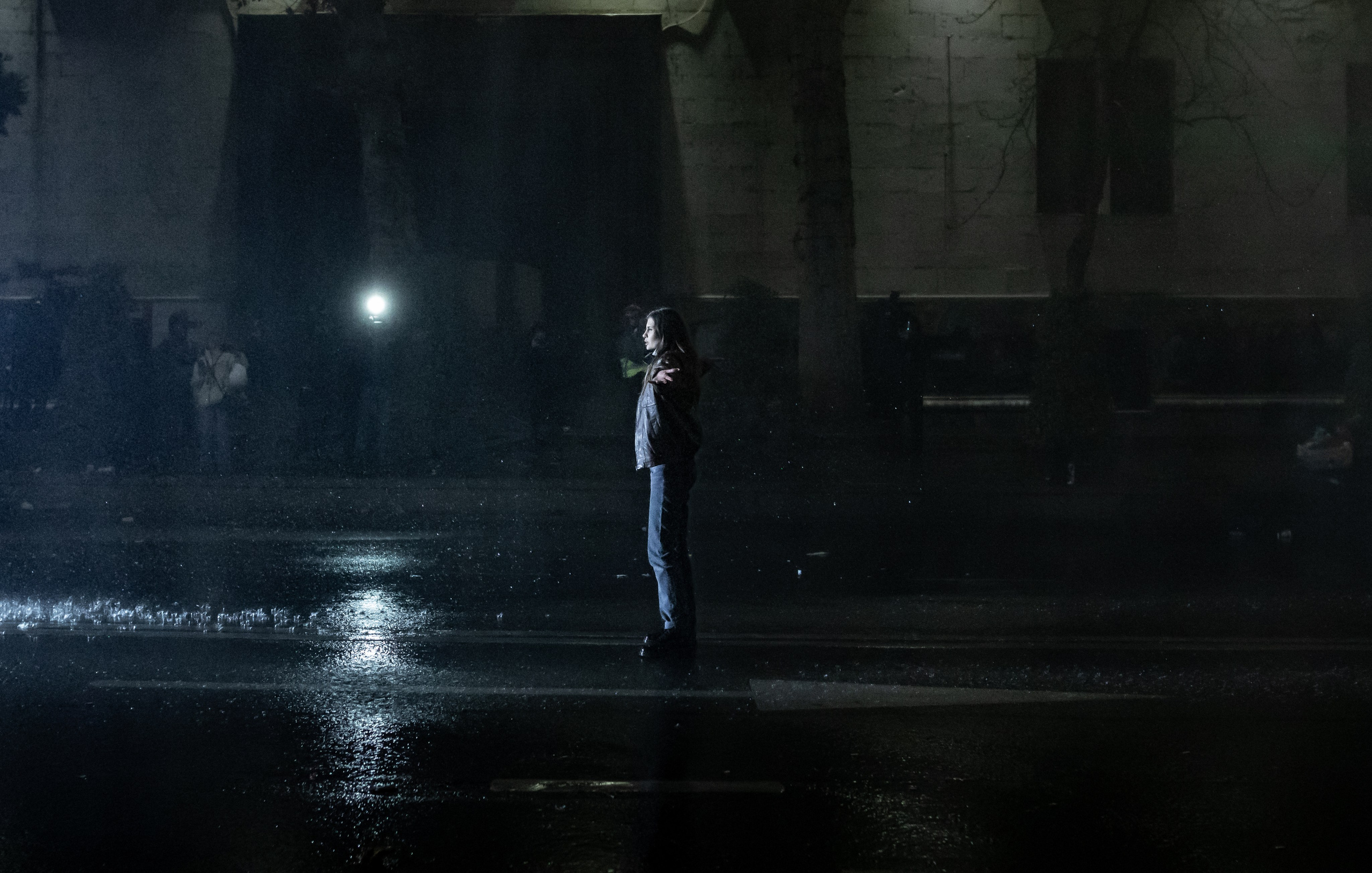 Une jeune femme fait face aux canons à eau des forces de l’ordre.