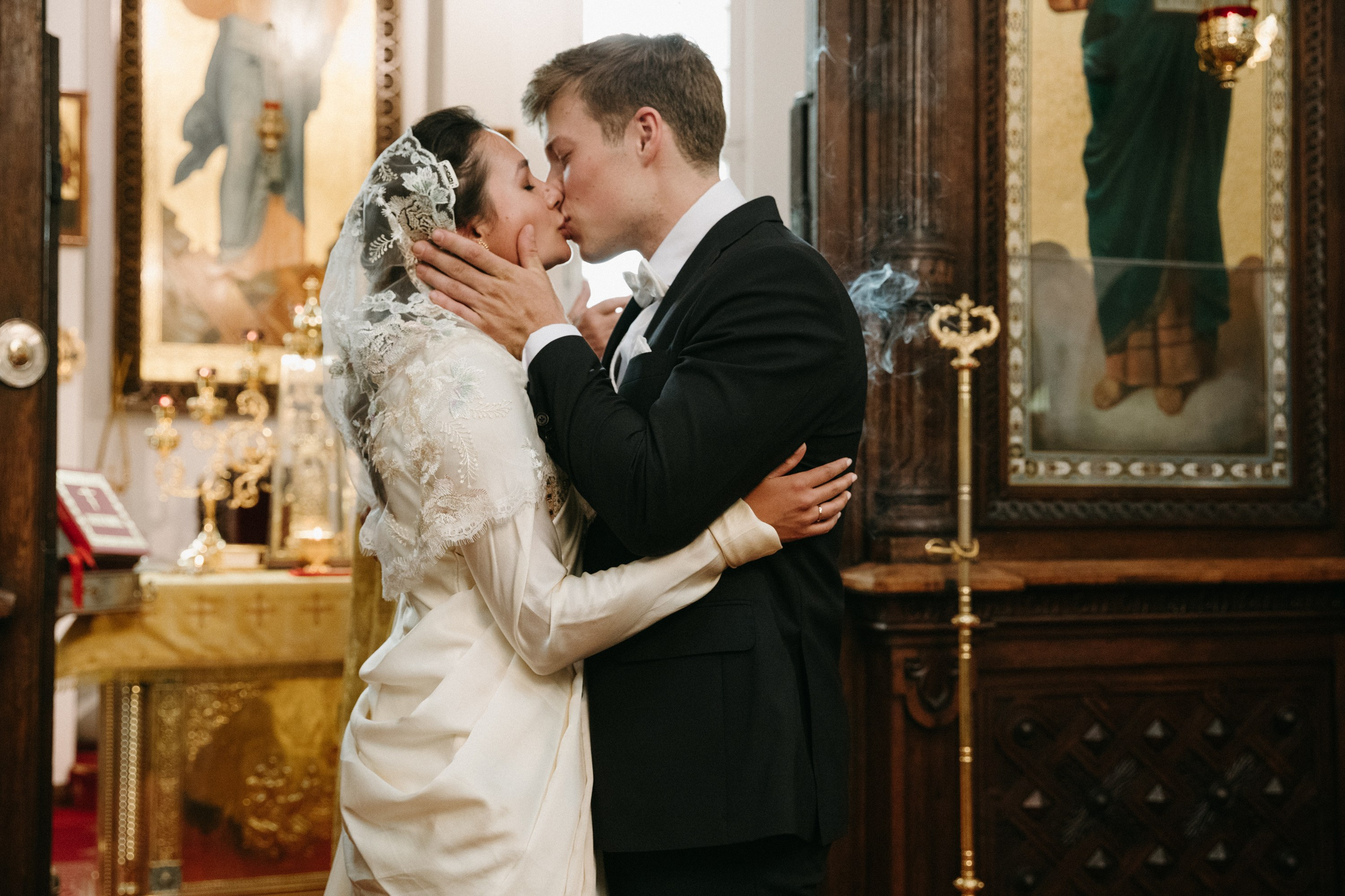 Braut und Bräutigam küssen sich nach der orthodoxen Trauung am Altar