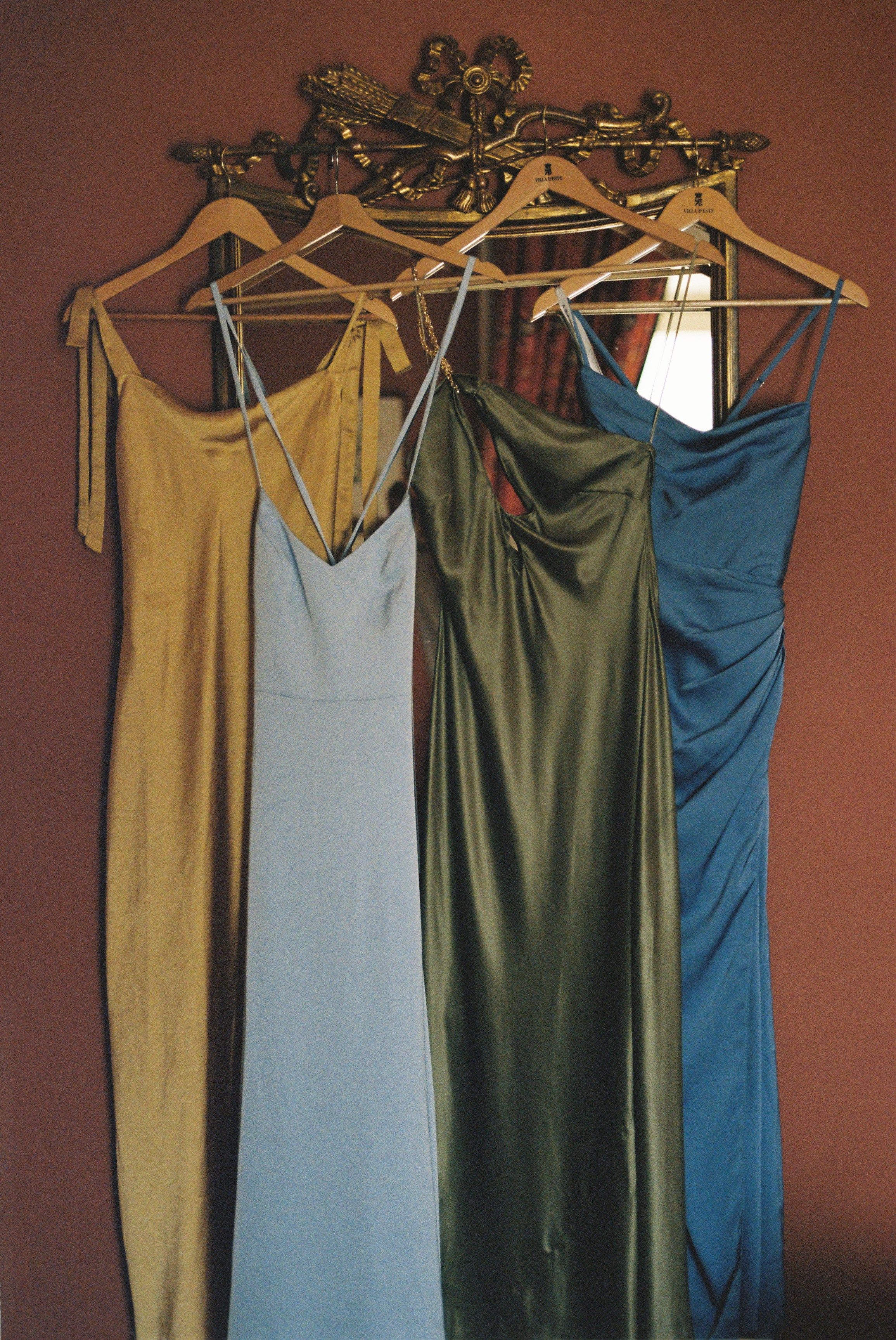Elegant dresses in warm hues hang side by side, ready for a stylish wedding celebration.