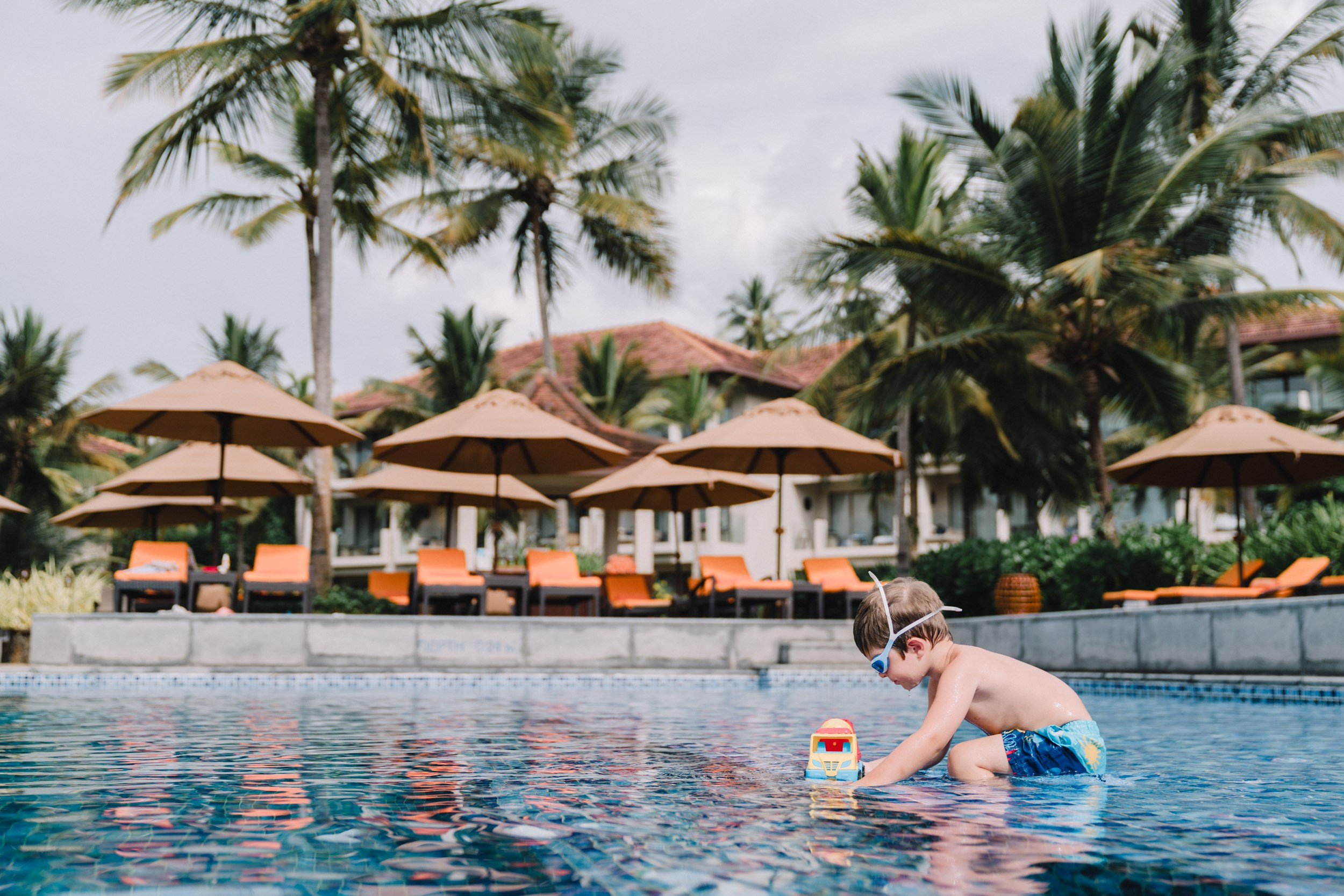 Luxury five star hotel pool with boy playing with the toy car