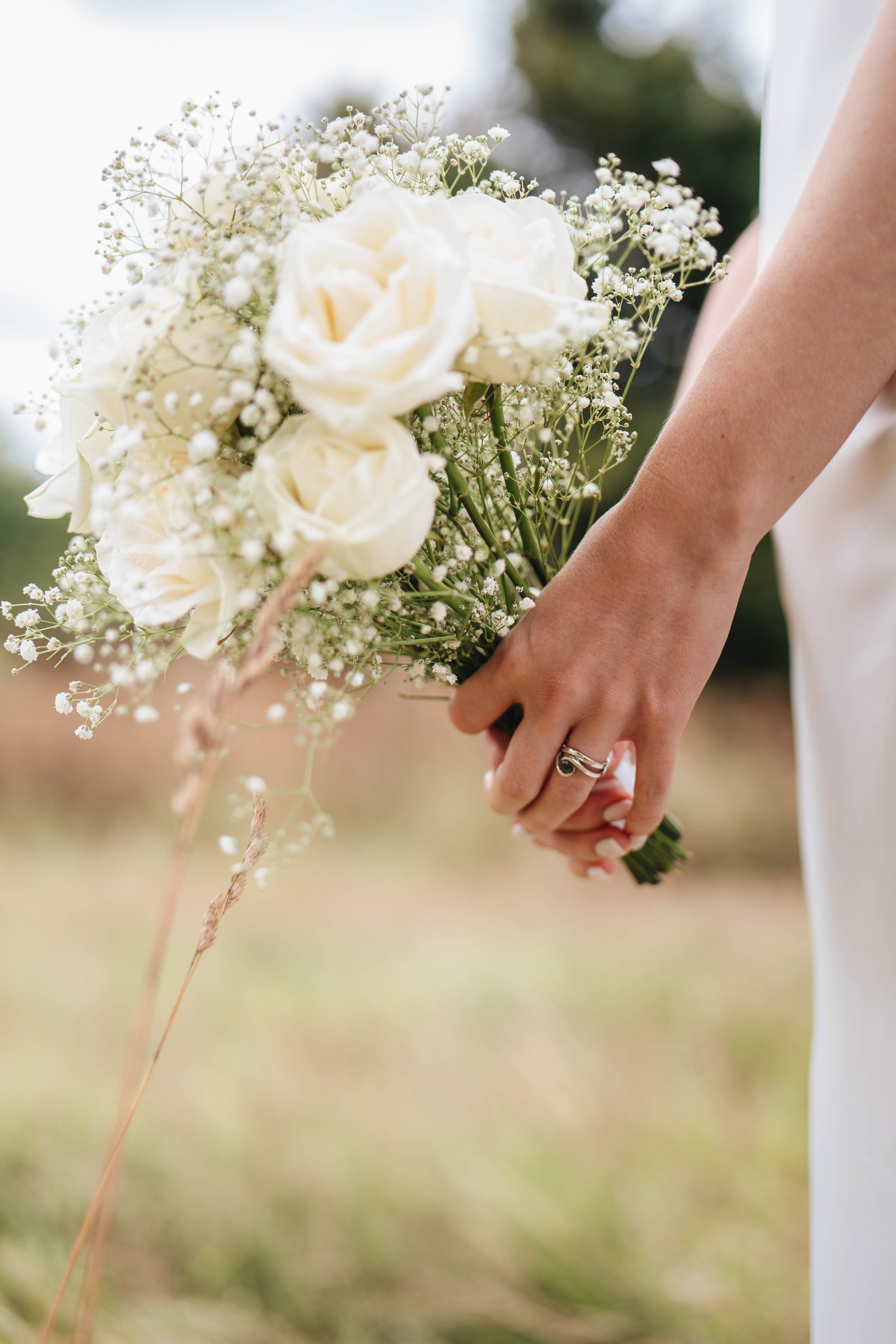 close up of the bride's hands holding white roses
