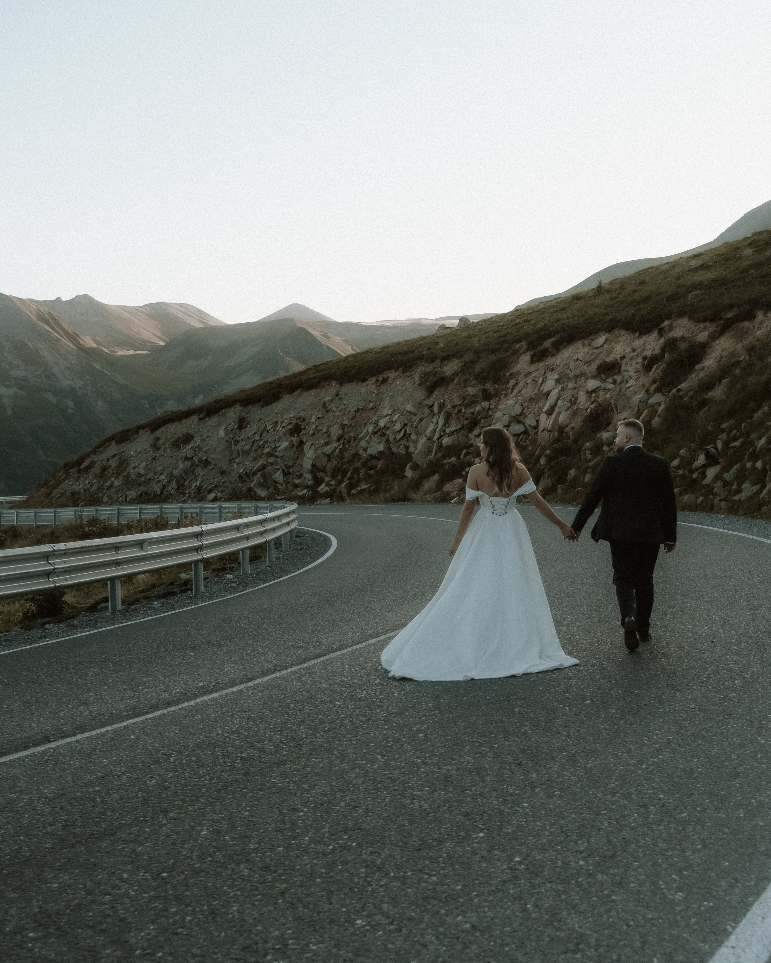 Couple walking down the mountain road in Gudauri during their wedding photoshoot 