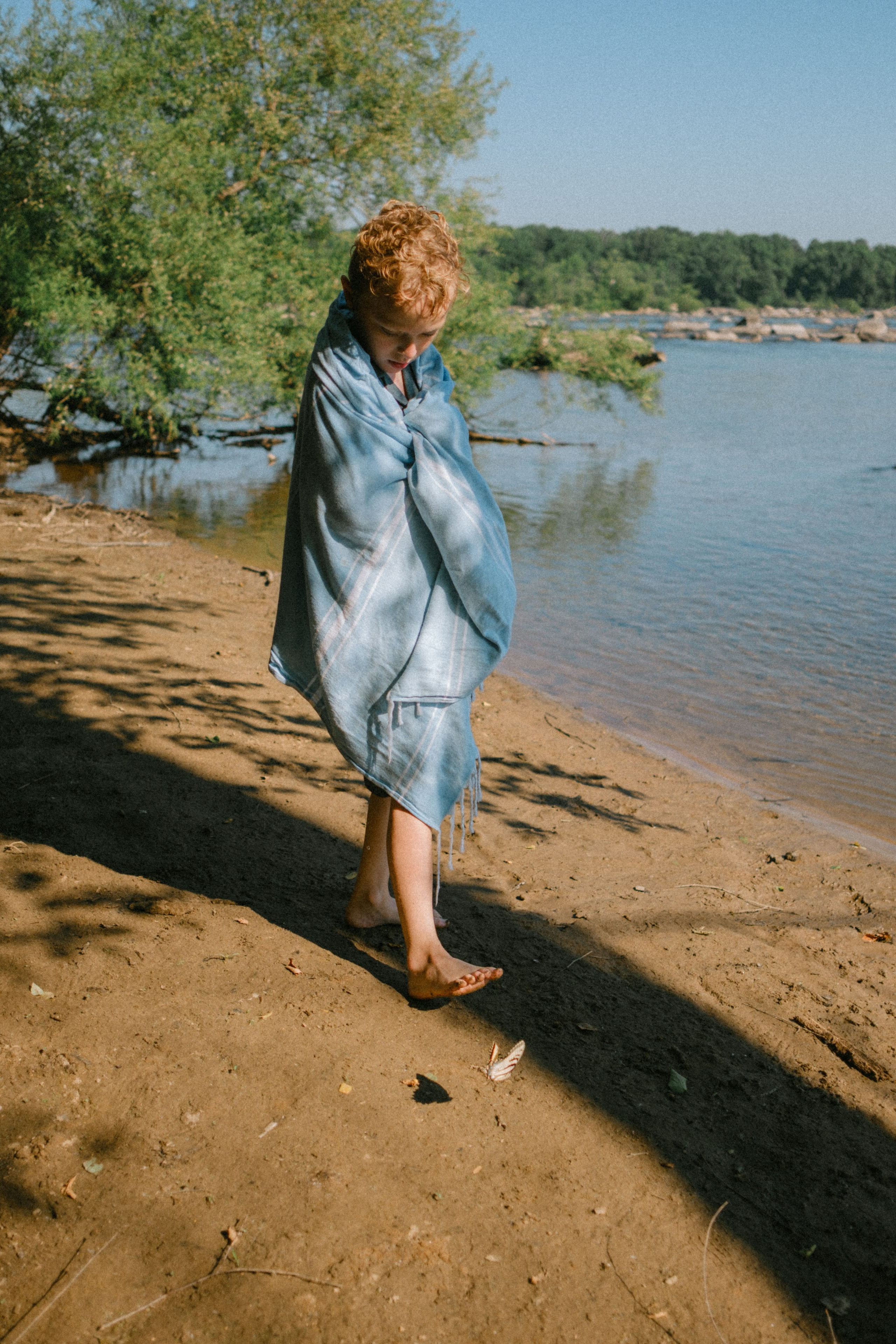 Beautiful, cinematic family portrait capturing a genuine, unposed moment on the river rocks in Richmond, VA