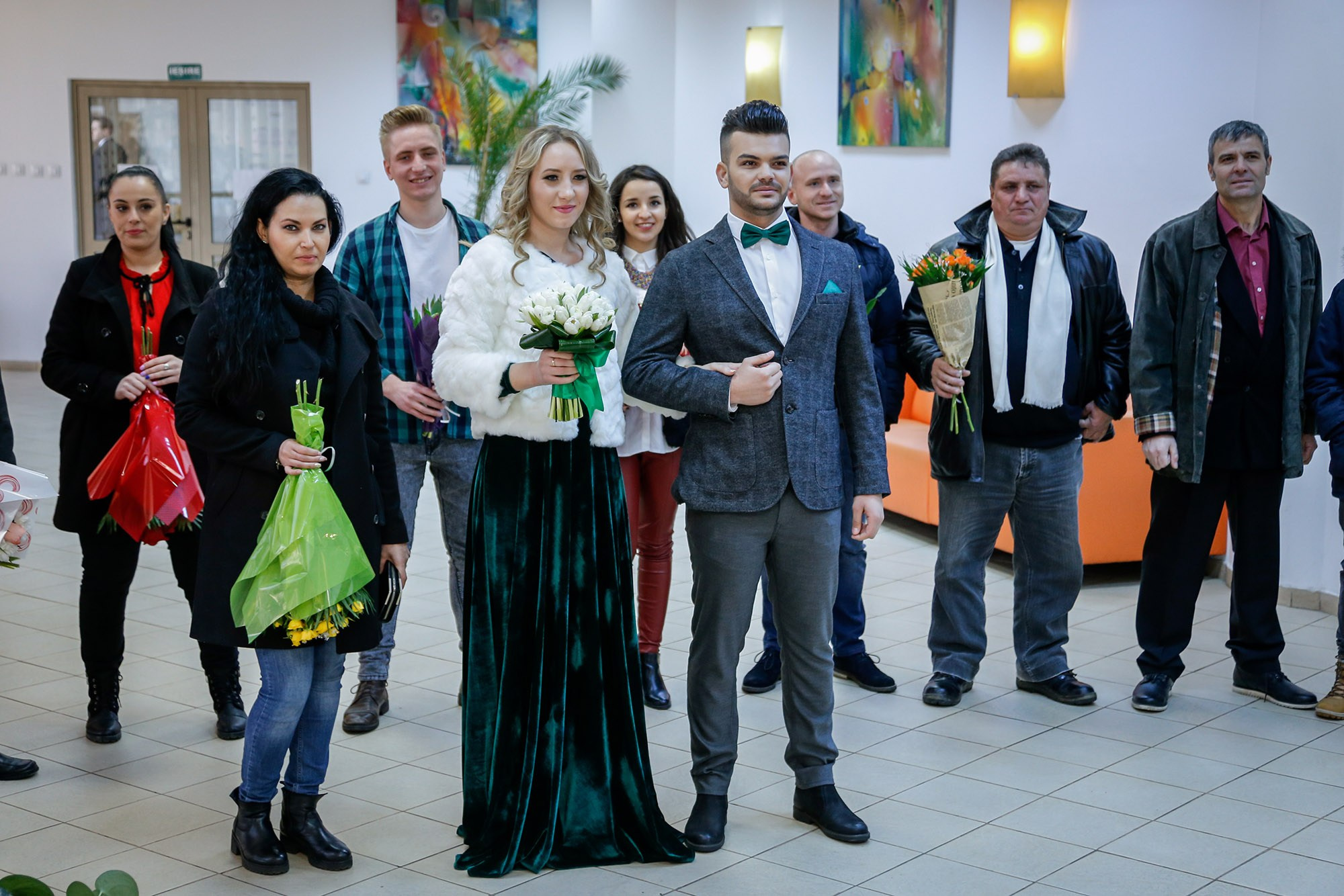 Group photo featuring the newlyweds and smiling guests inside the civil wedding hall, captured by a professional photographer.