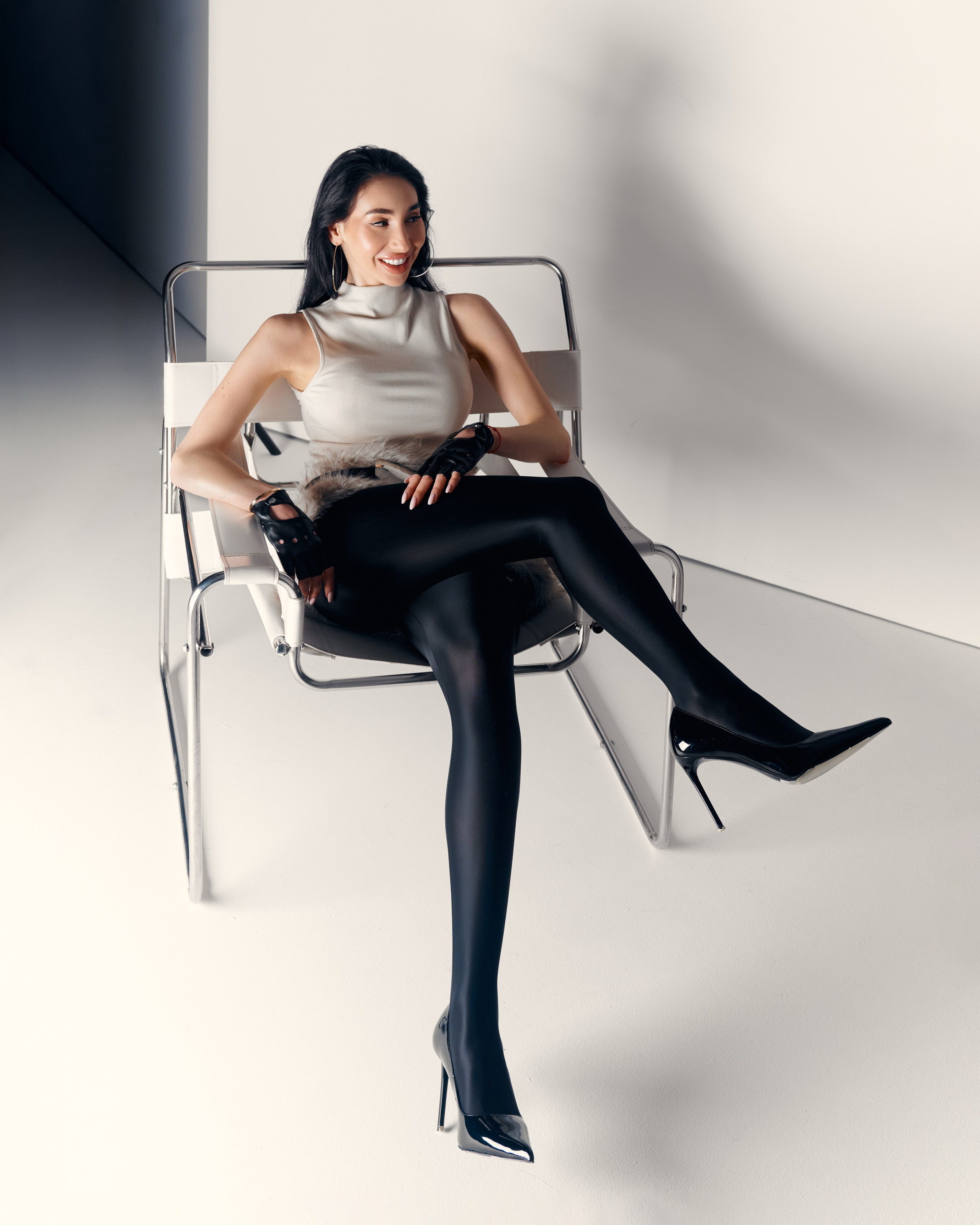 Modern editorial portrait of Ester Rogovaya wearing a fur skirt in a minimalist studio setting