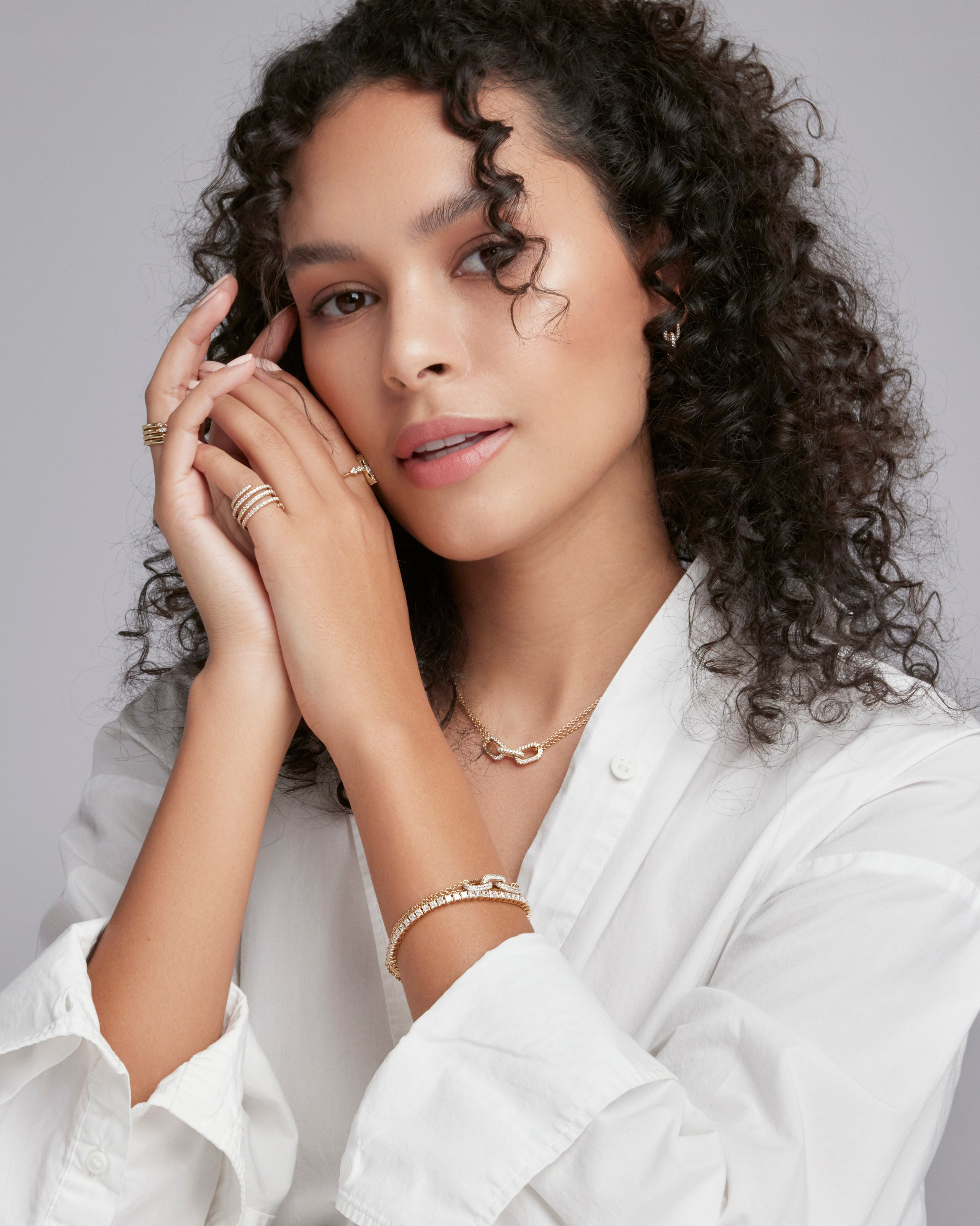 Close-up portrait of a model wearing elegant gold rings, highlighting luxury accessories.