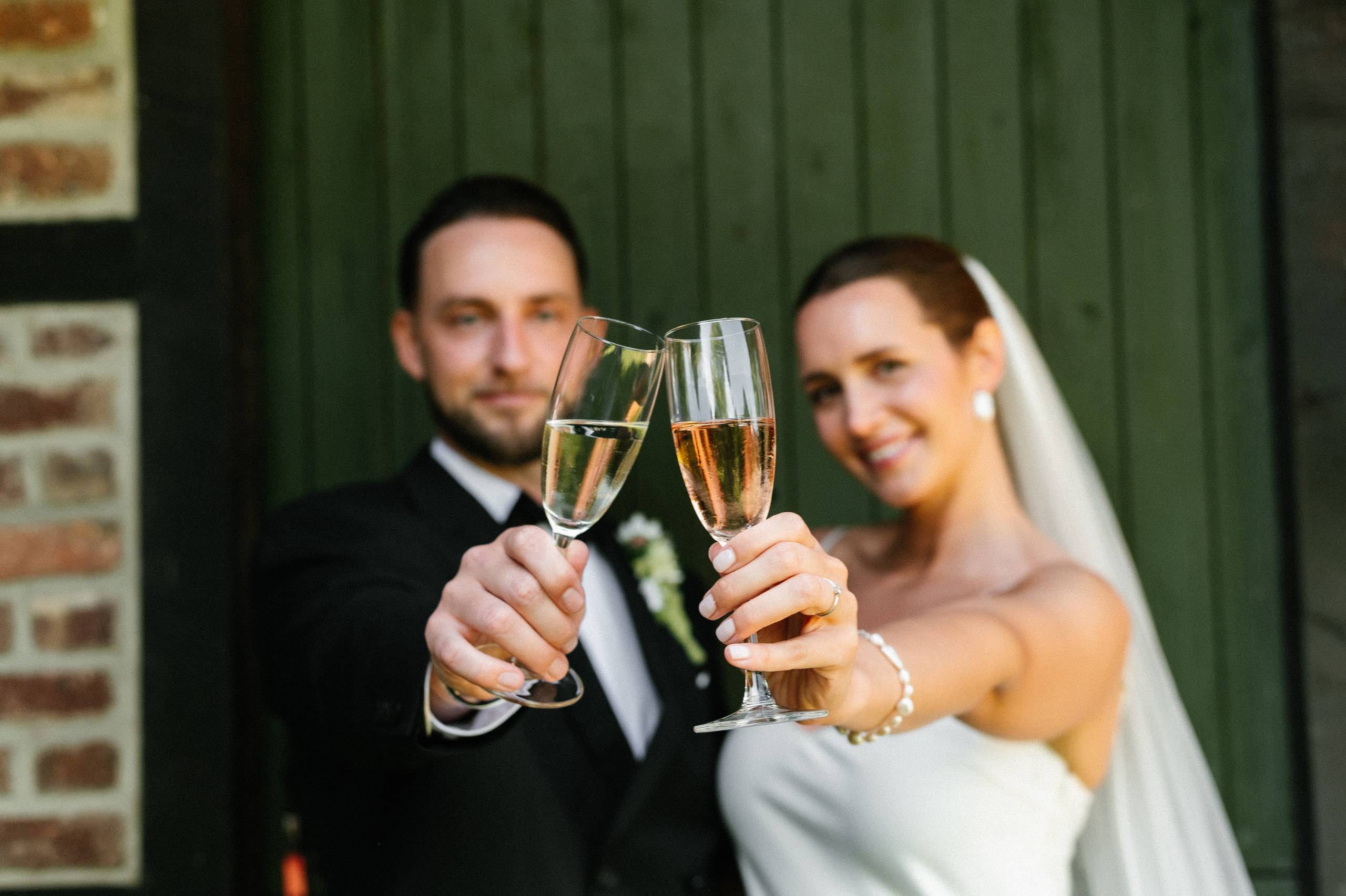 Braut und Bräutigam stoßen fröhlich mit Sektgläsern an