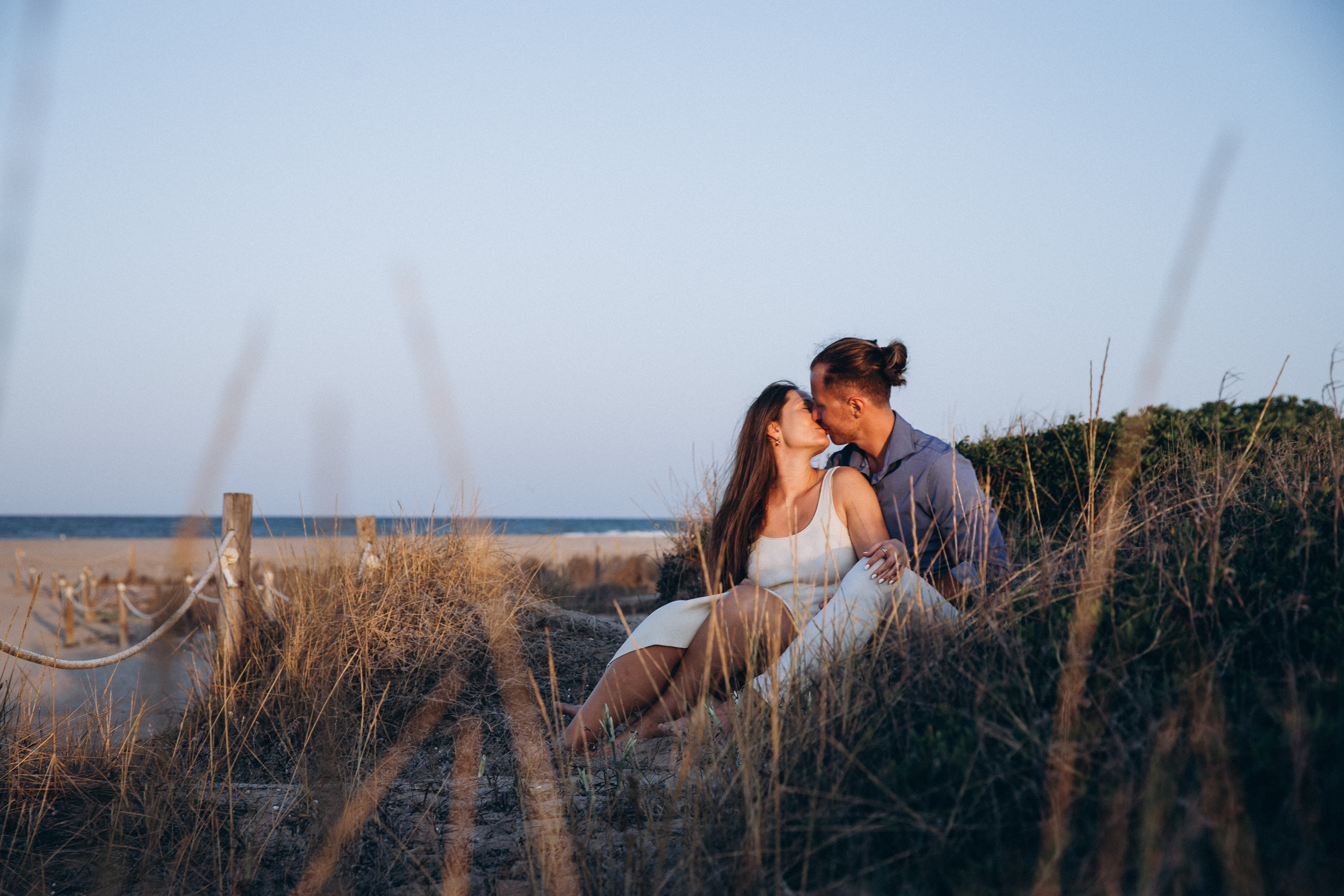 Sesión de fotos romántica de pareja en Valencia, España, capturando un tierno beso en un campo dorado al atardecer — ideal para quienes buscan sesiones íntimas y naturales de pareja o love story en Valencia y en entornos escénicos de España.