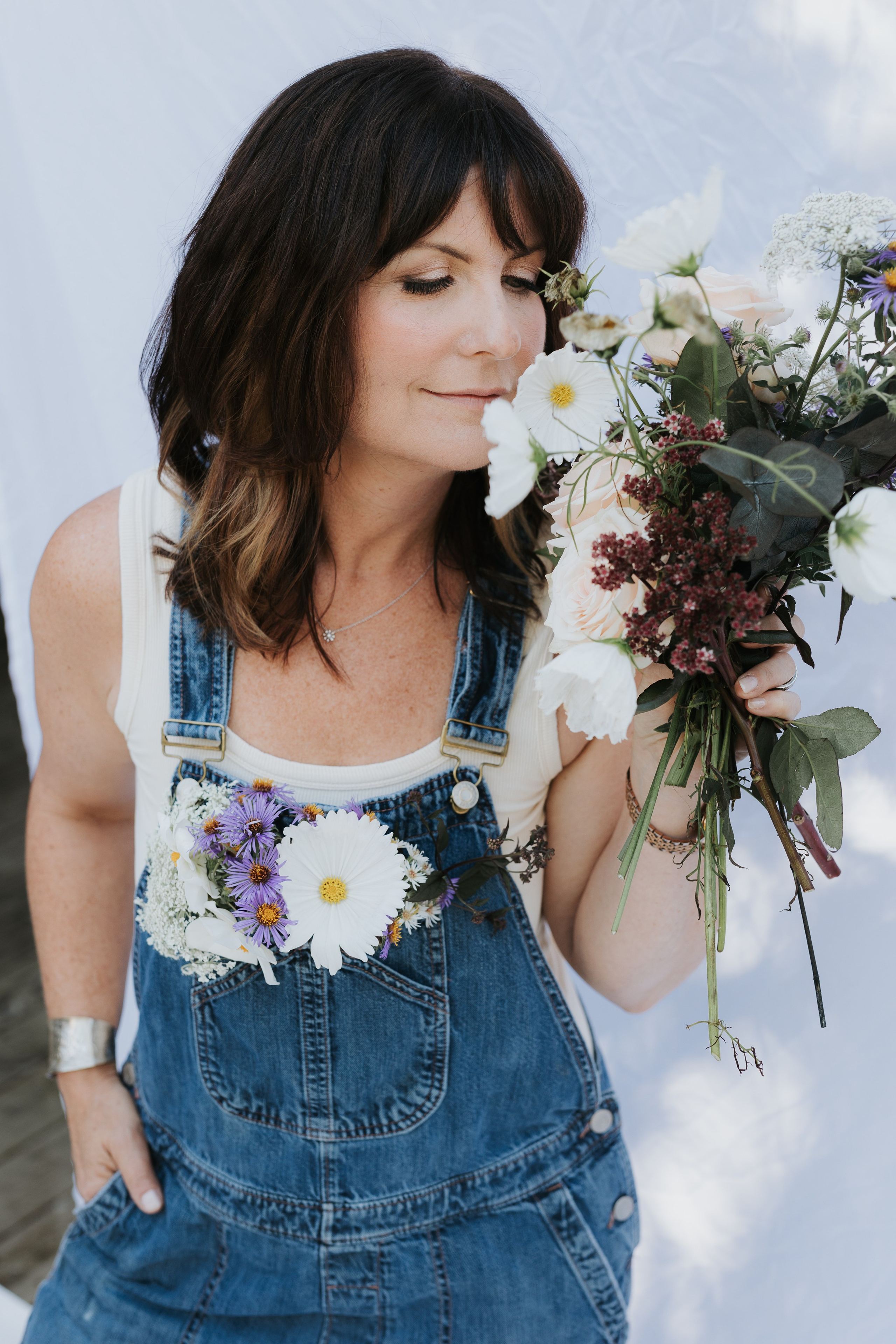 woman smelling wildflowers with a smile 