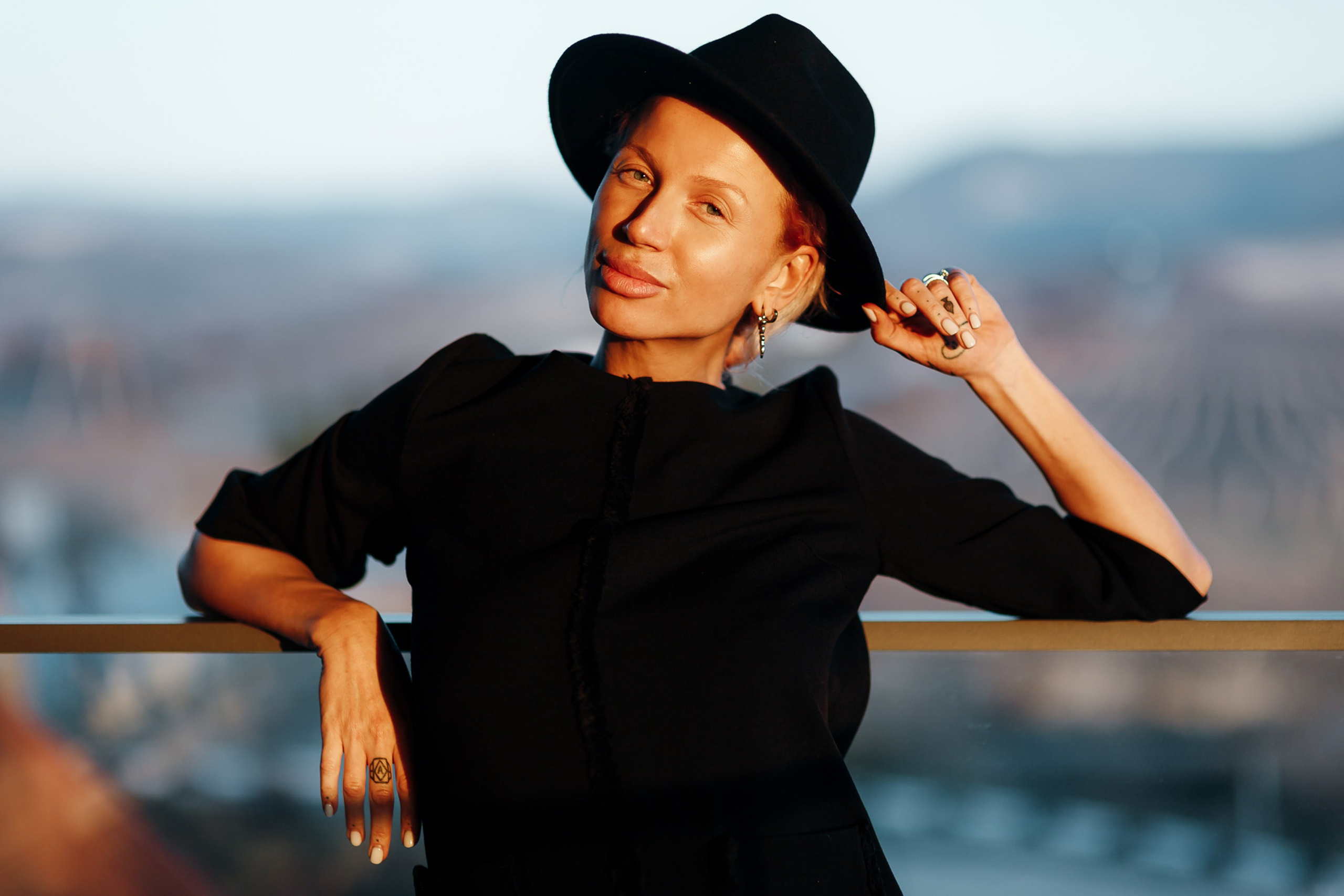 Woman in black top and hat near water