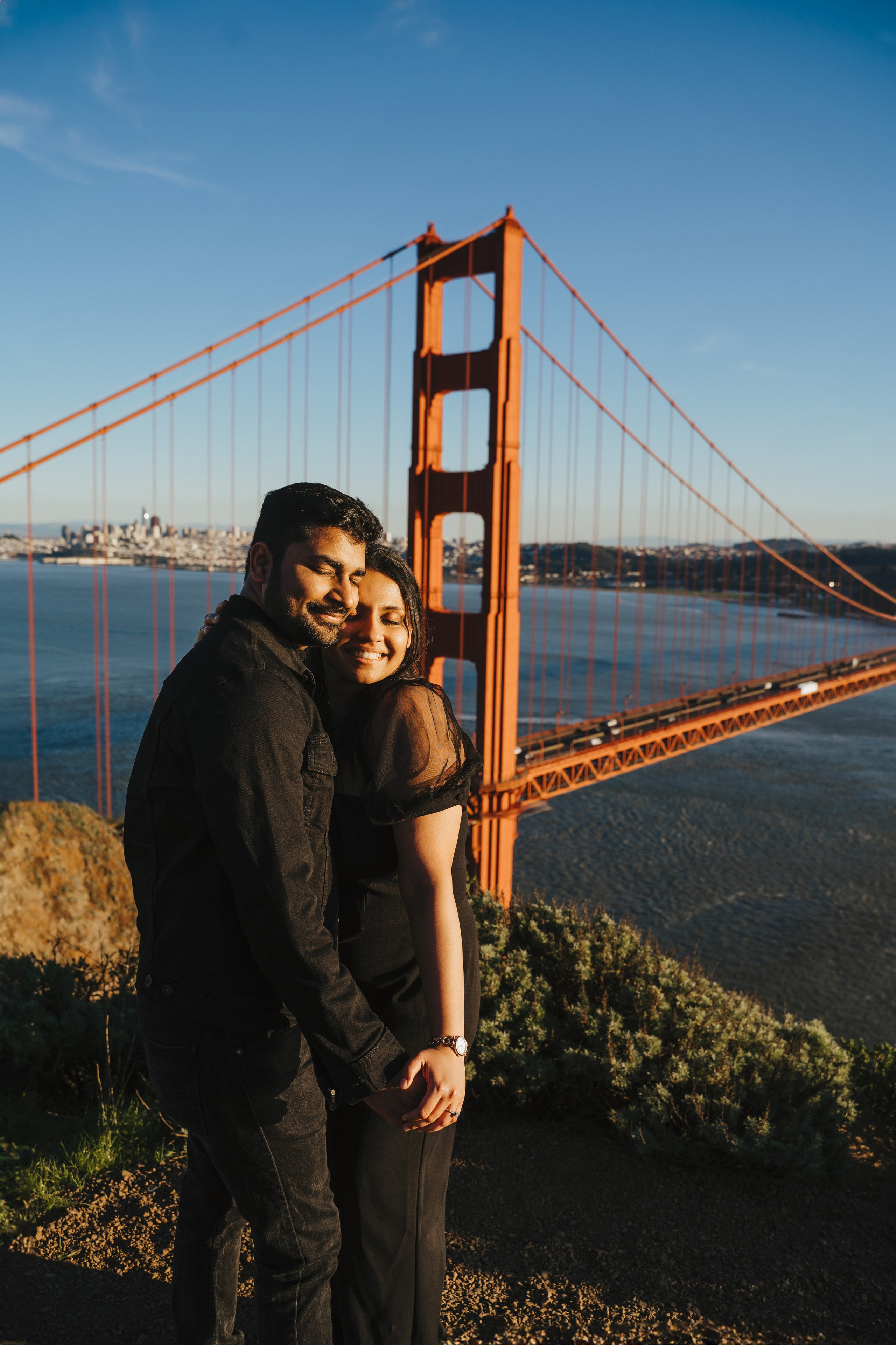 Proposal.  Overlooking the golden San Franisco Bridge sunset with a couple. Photographer Video. 