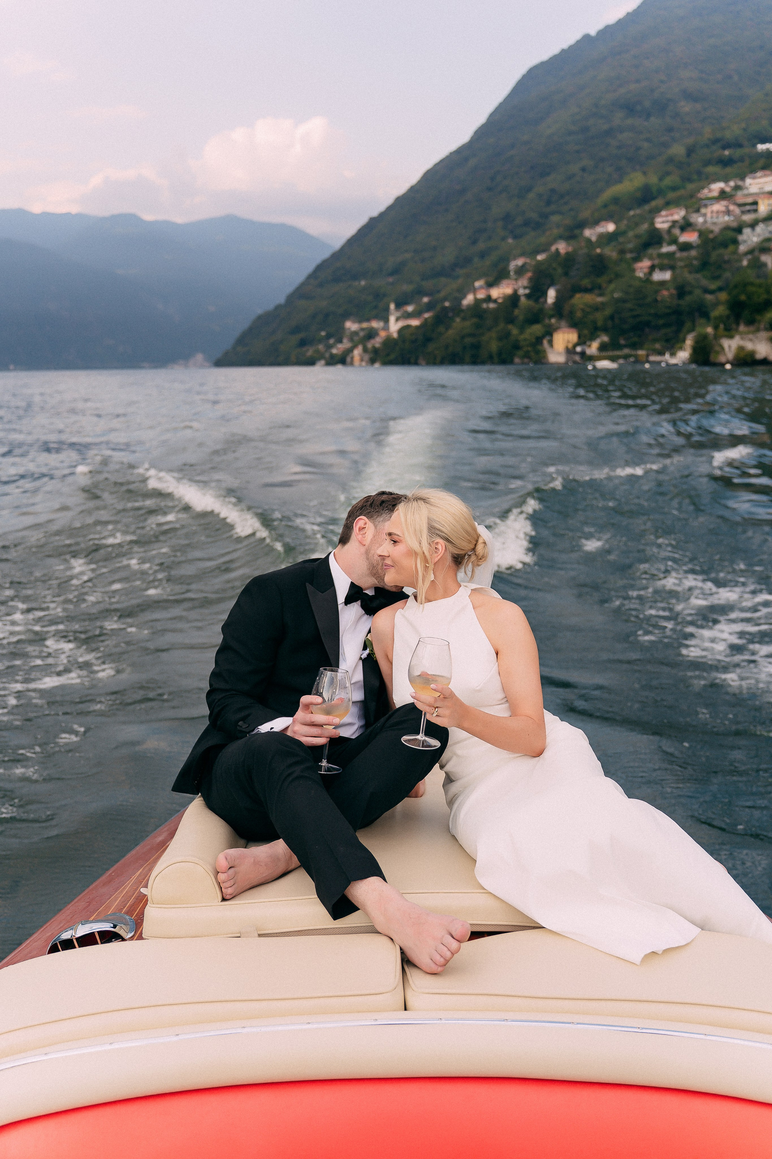 Bride and groom embracing on the boat at Villa Lario, Lake Como, Italy