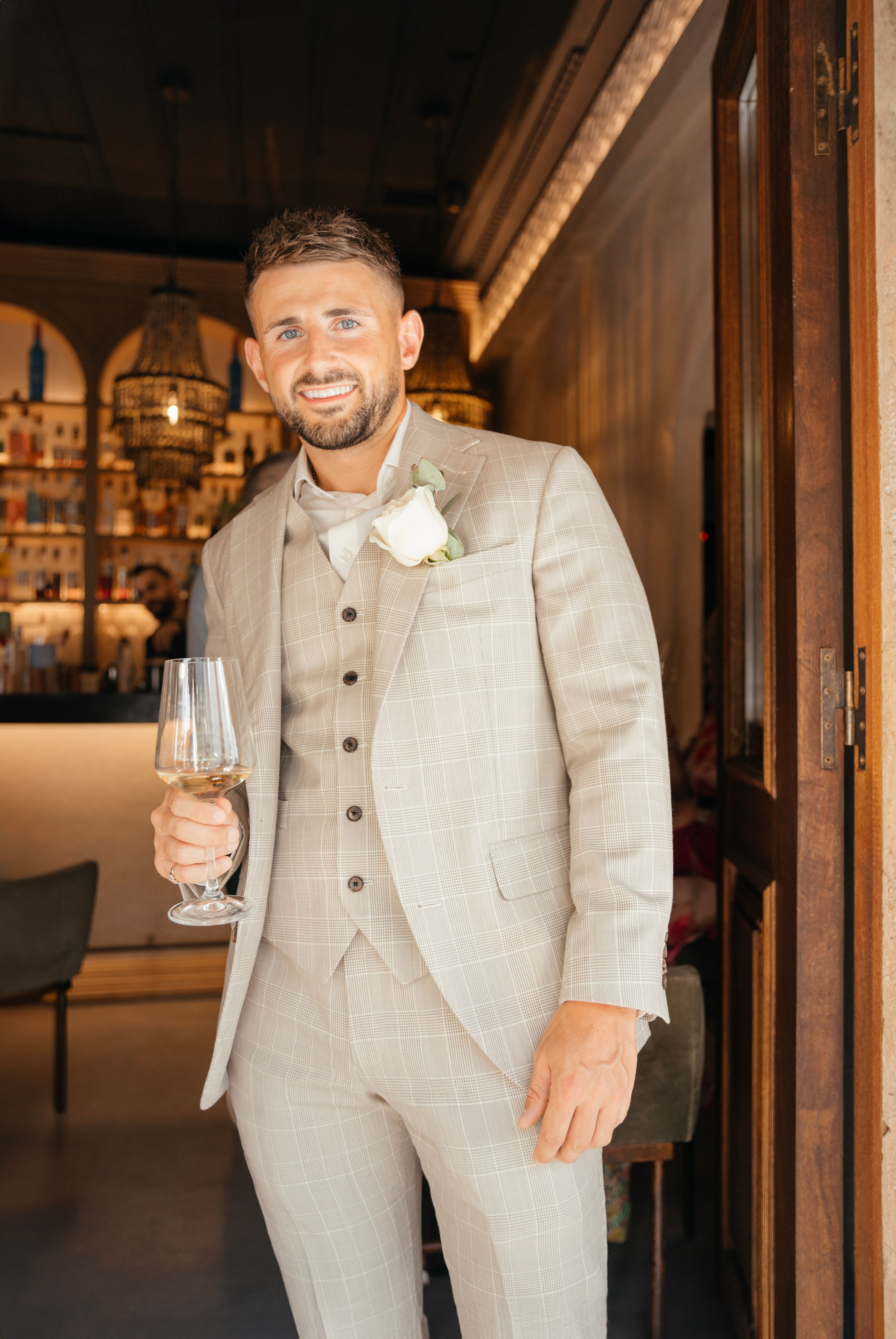 Groom is posing for a photo at a pre-wedding party in a traditional Greek bar in Lindos