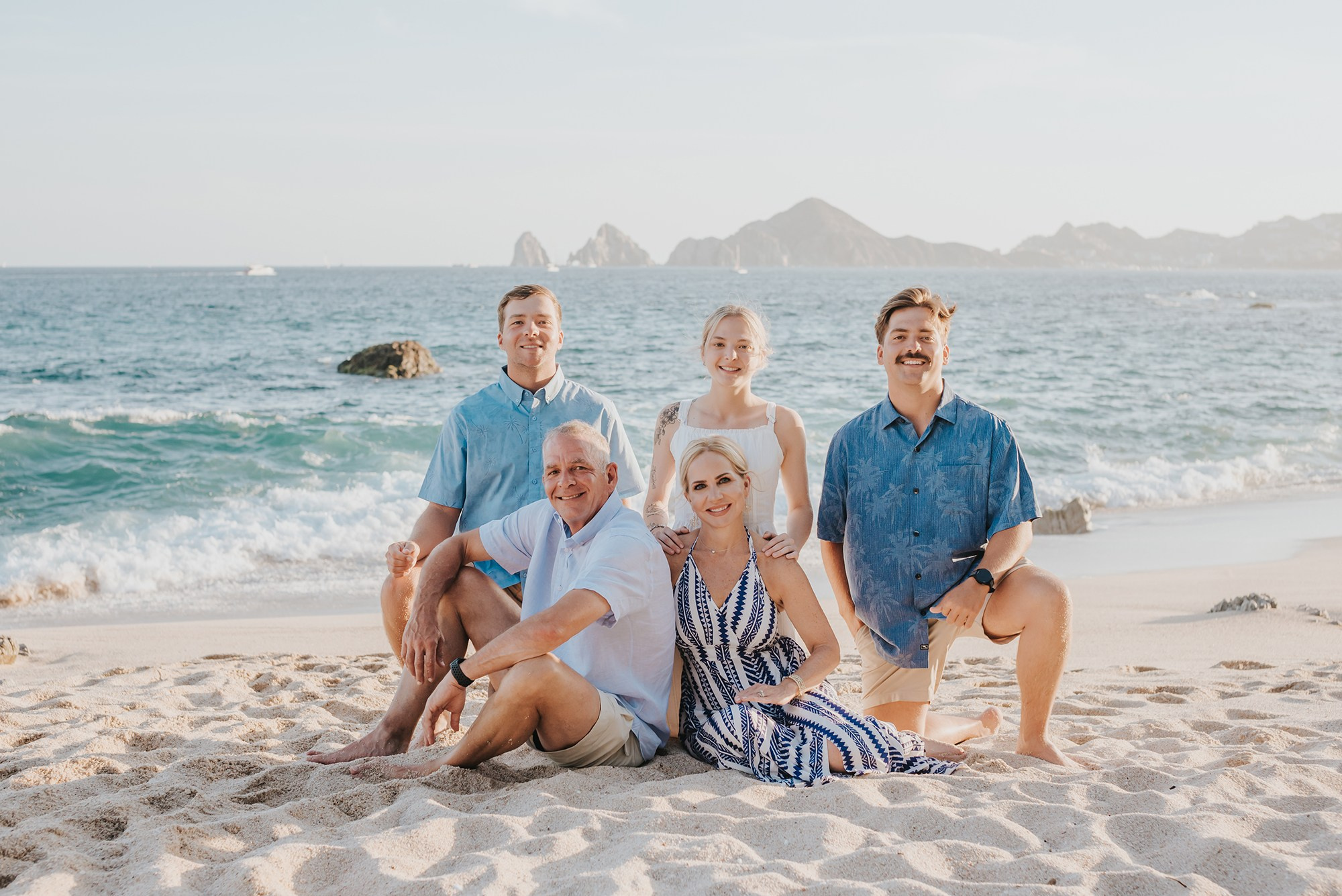 Family portrait in Cabo San Lucas – family of five smiling with ocean and iconic Arch in the background, cinematic beach family photography in Los Cabos