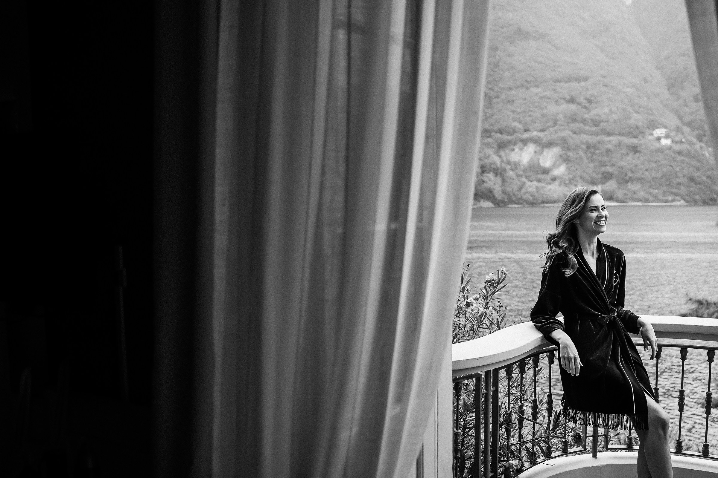 The bride standing on the Villa Relais Vittoria balcony with stunning view of the Lake Como. 