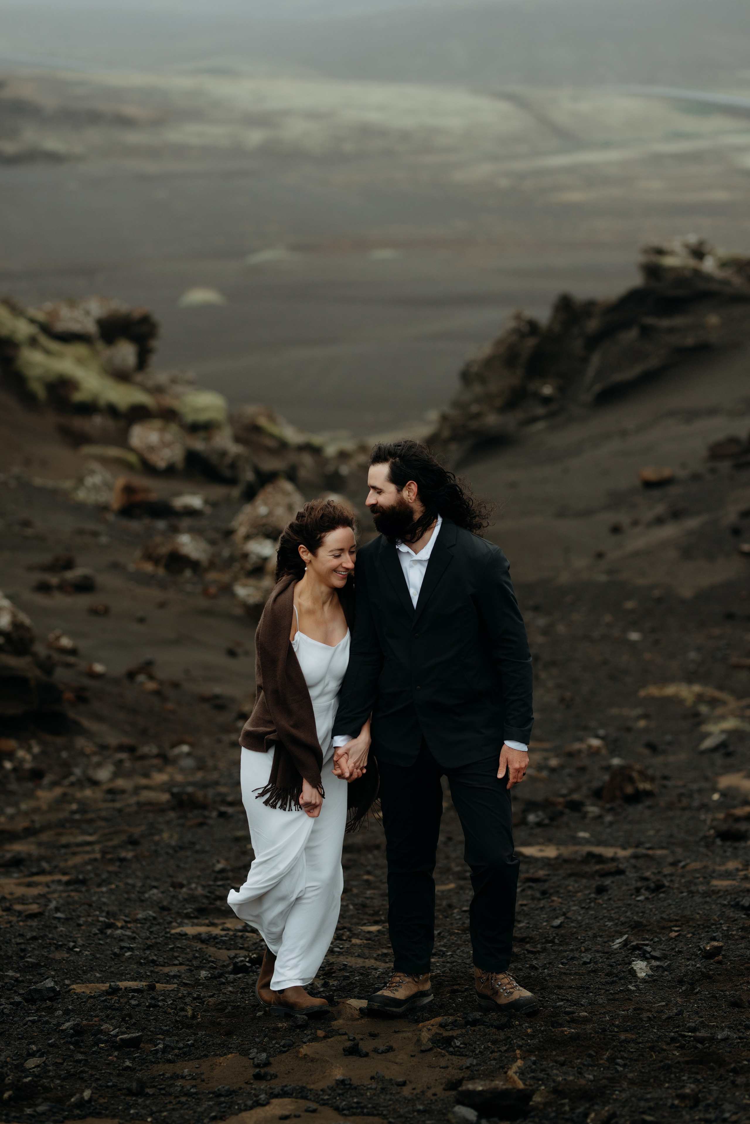 Romantic moment between bride and groom in Krýsuvík, with dramatic volcanic hills in the background.