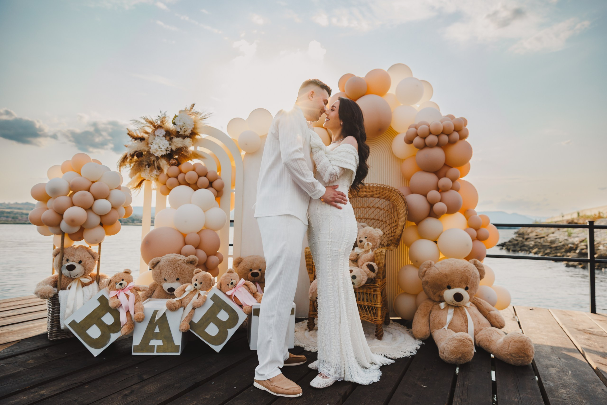 Sărut tandru lângă decoruri gender reveal cu urși de pluș