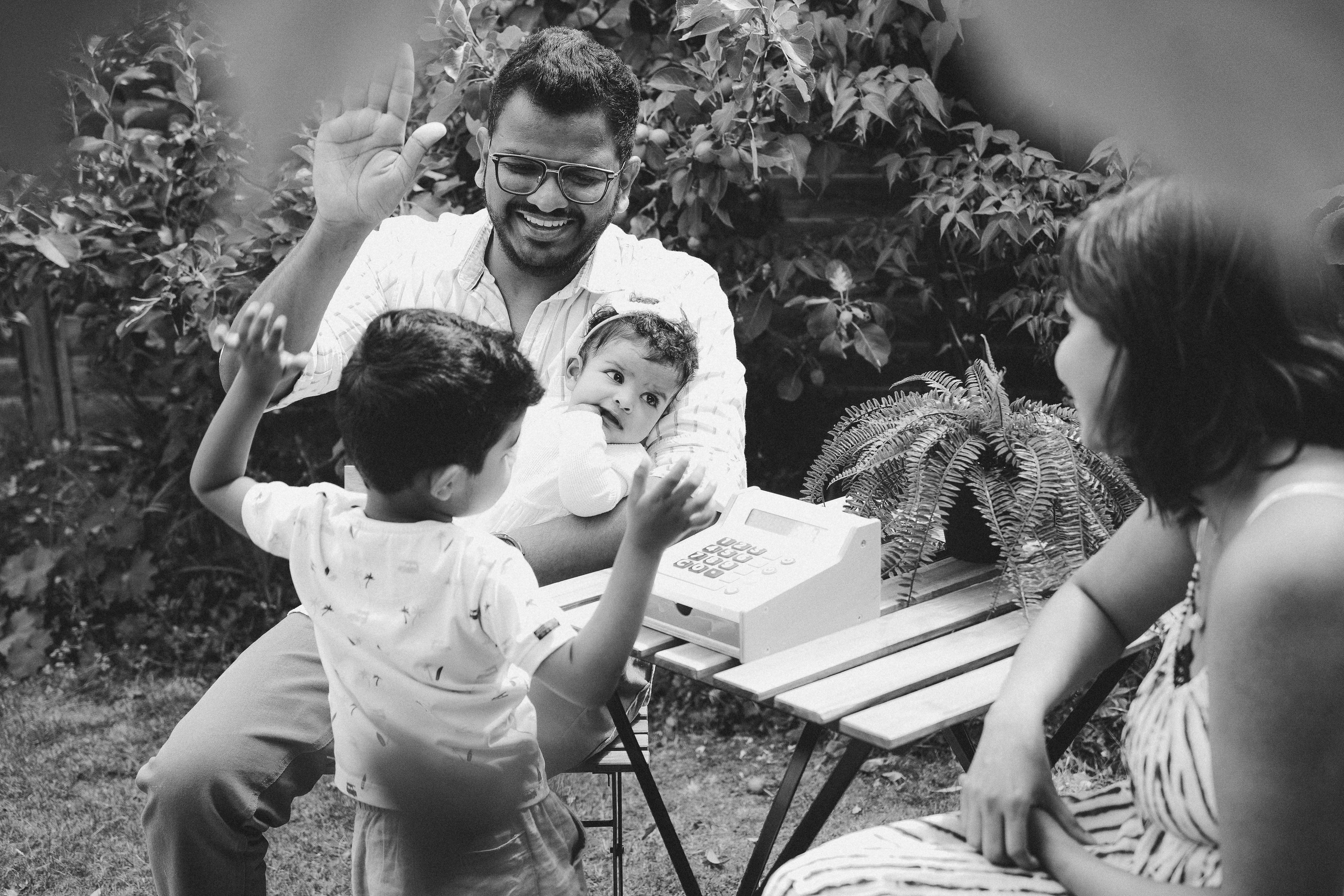 Black and white family photo capturing natural interaction between parents and children