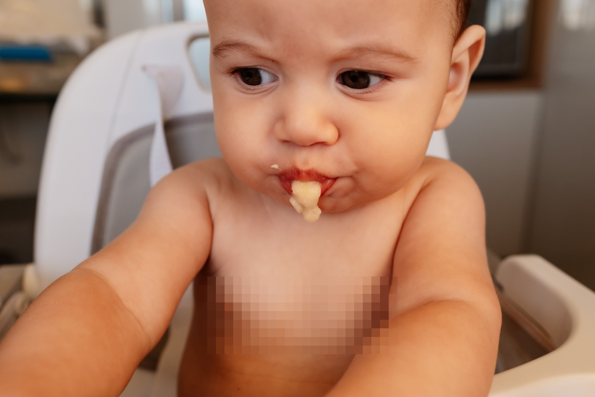 Bebê experimenta comida durante fase de introdução alimentar.