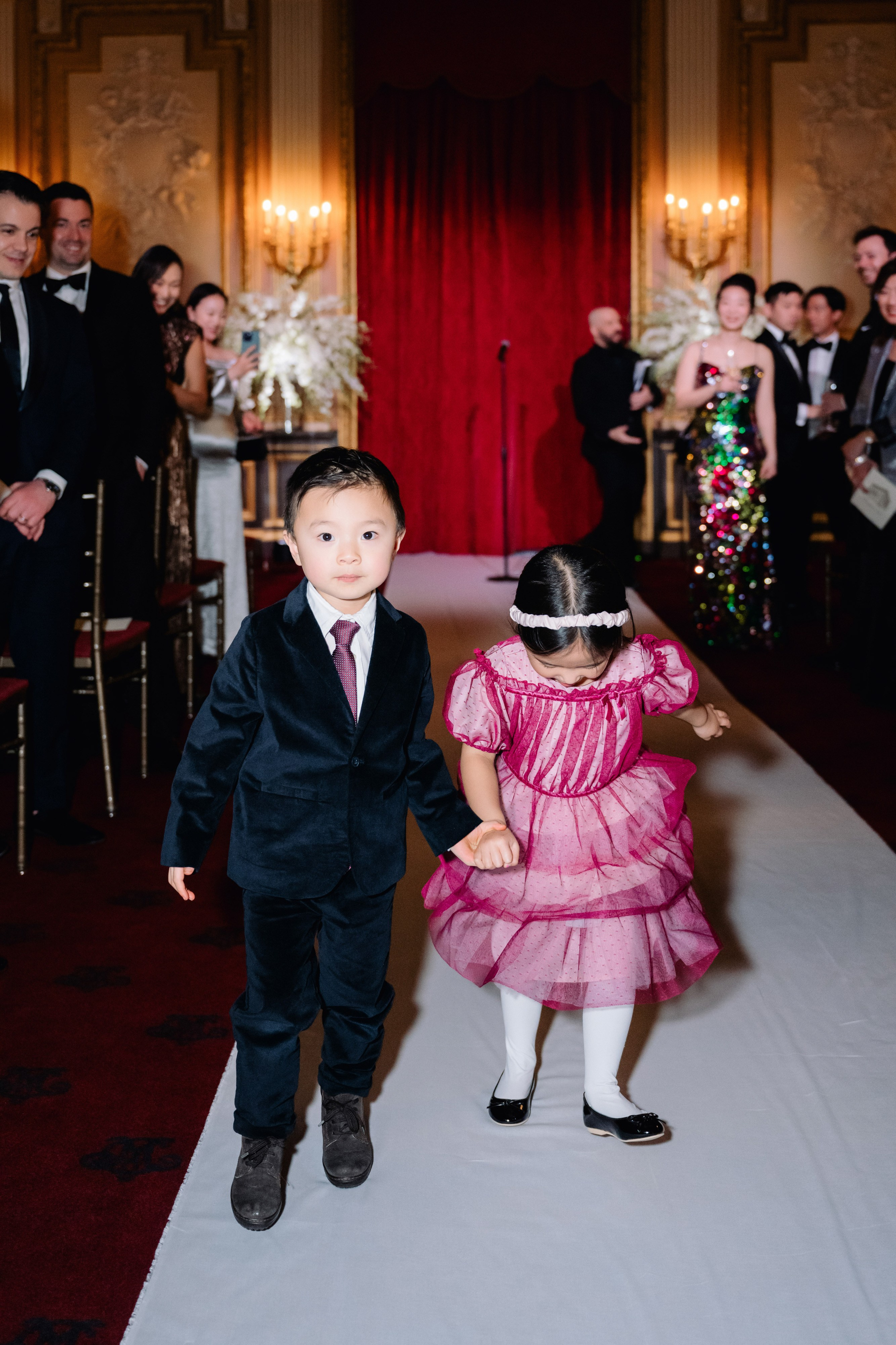 a little girl in a pink dress and a little boy in a black suit