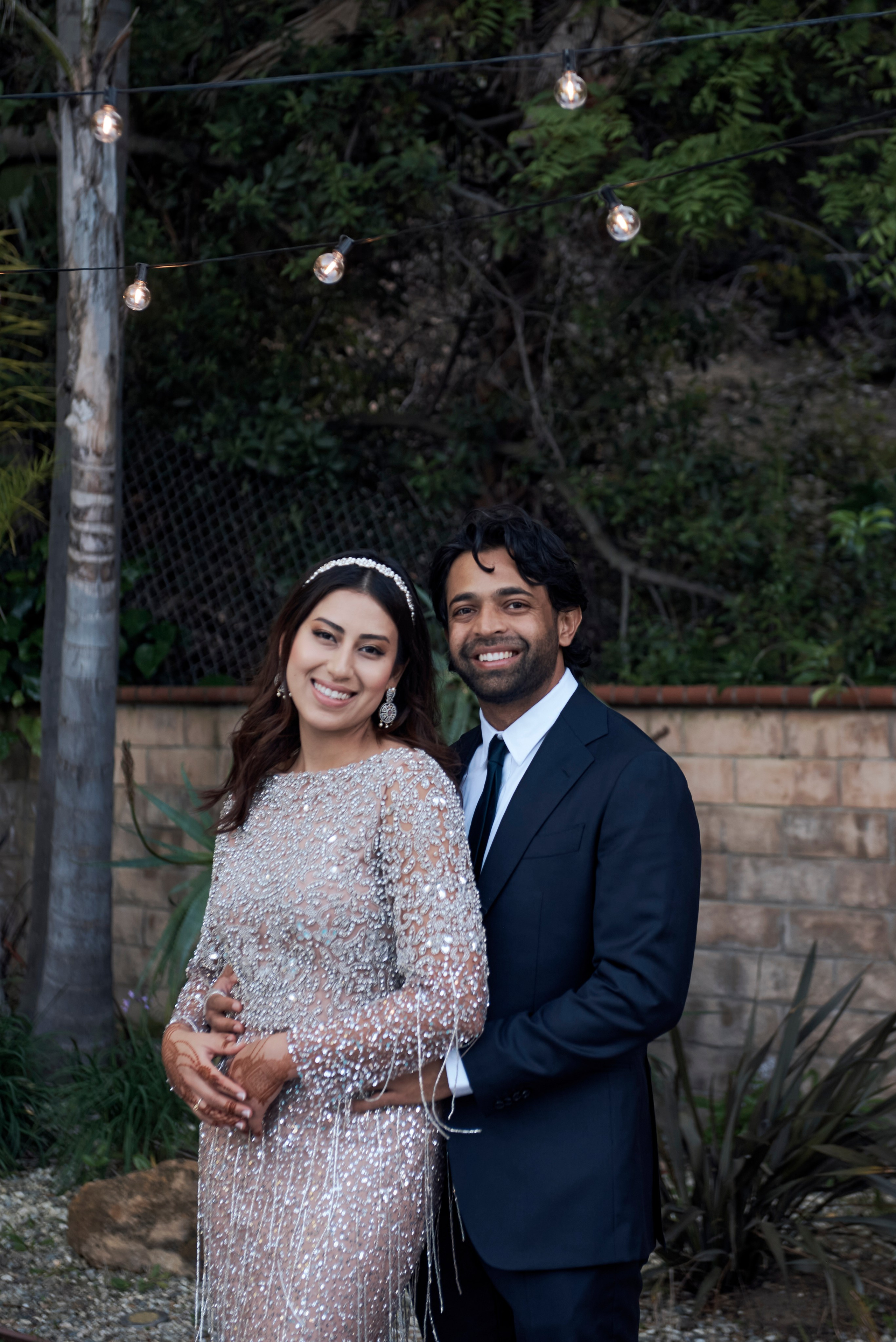 Engaged couple holding hands and laughing in front of iconic Los Angeles cityscape