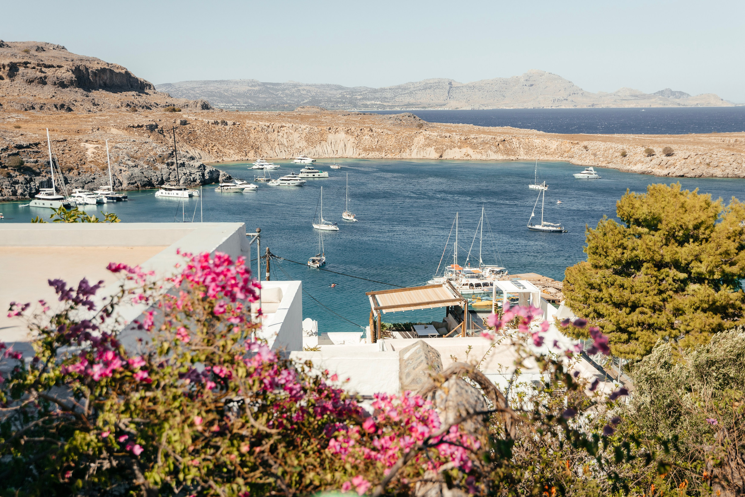 Aerial view of the wedding venue in Lindos, showcasing the white and blue decor blending perfectly with the Greek island scenery. Wedding photographer, Rhodes