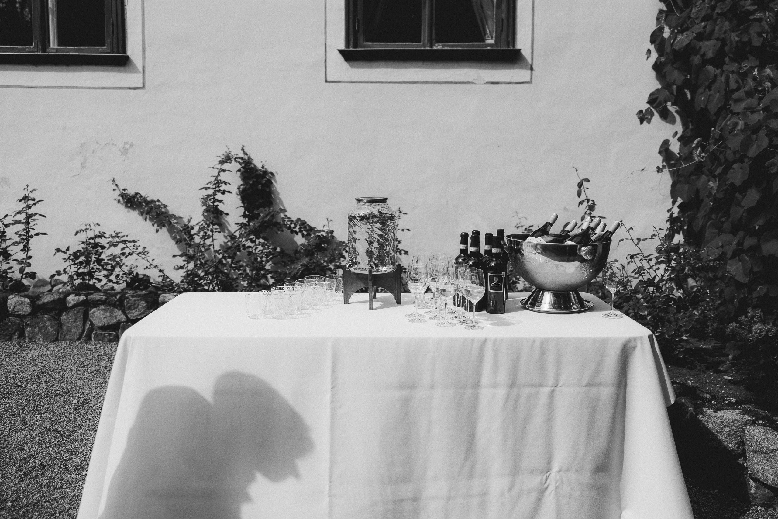 Melnbalts kadrs ar elegantu galda klājumu un dekorācijām muižas pagalmā.
