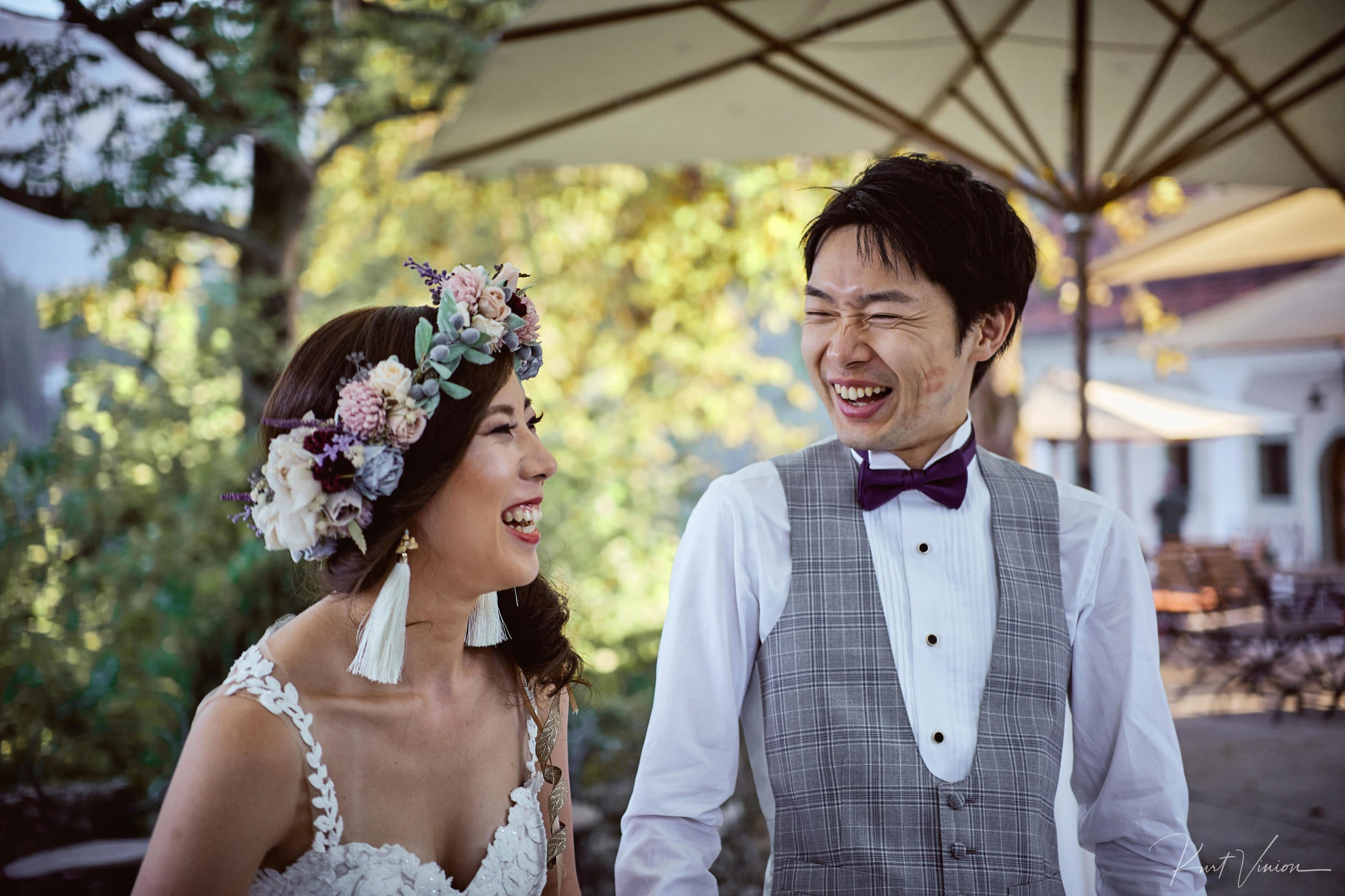 Japanese couple bursting into hearty laughter post-ceremony moment.