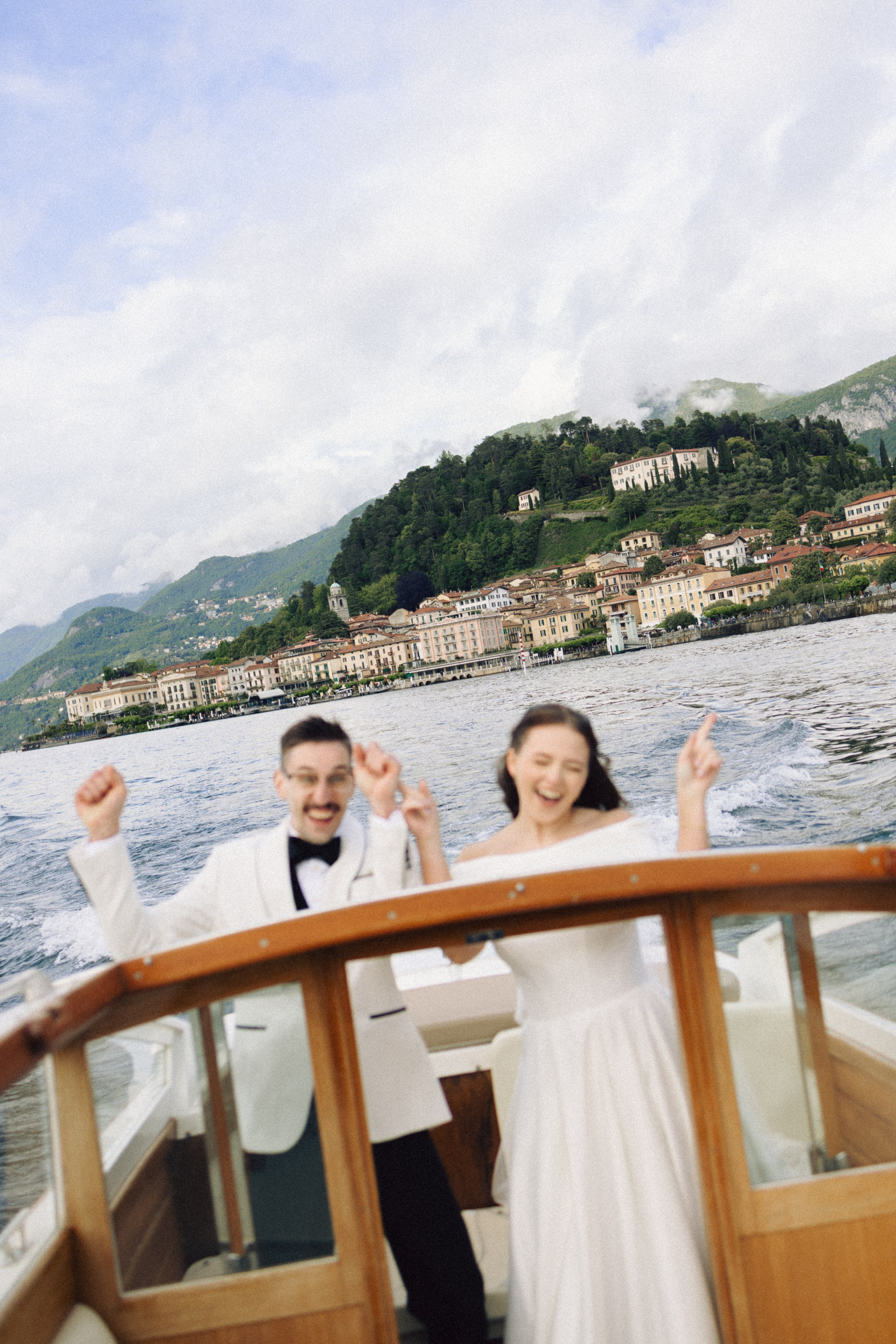Newlyweds celebrating on a wooden boat during their Lake Como elopement in Italy