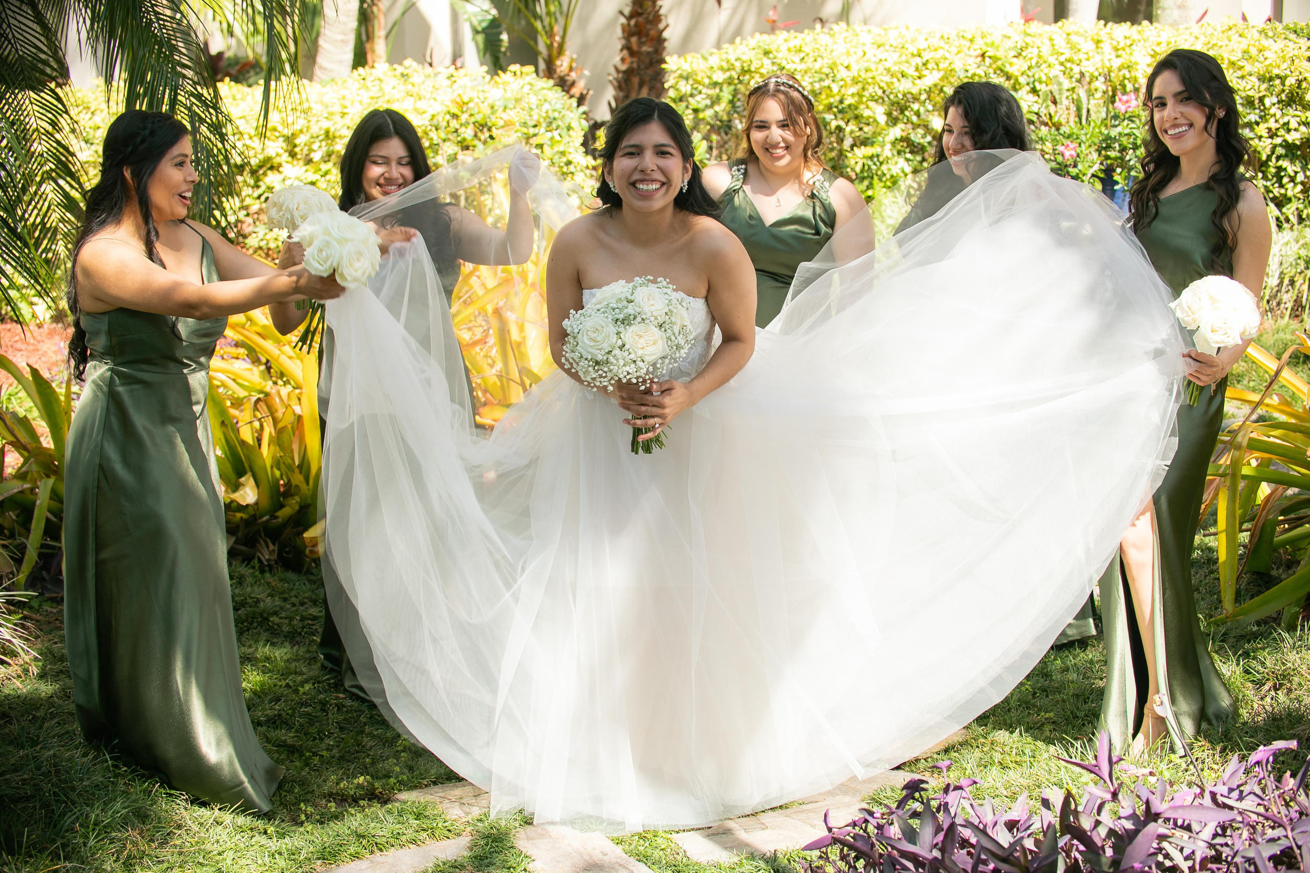 bridesmaids holding the bride's dress