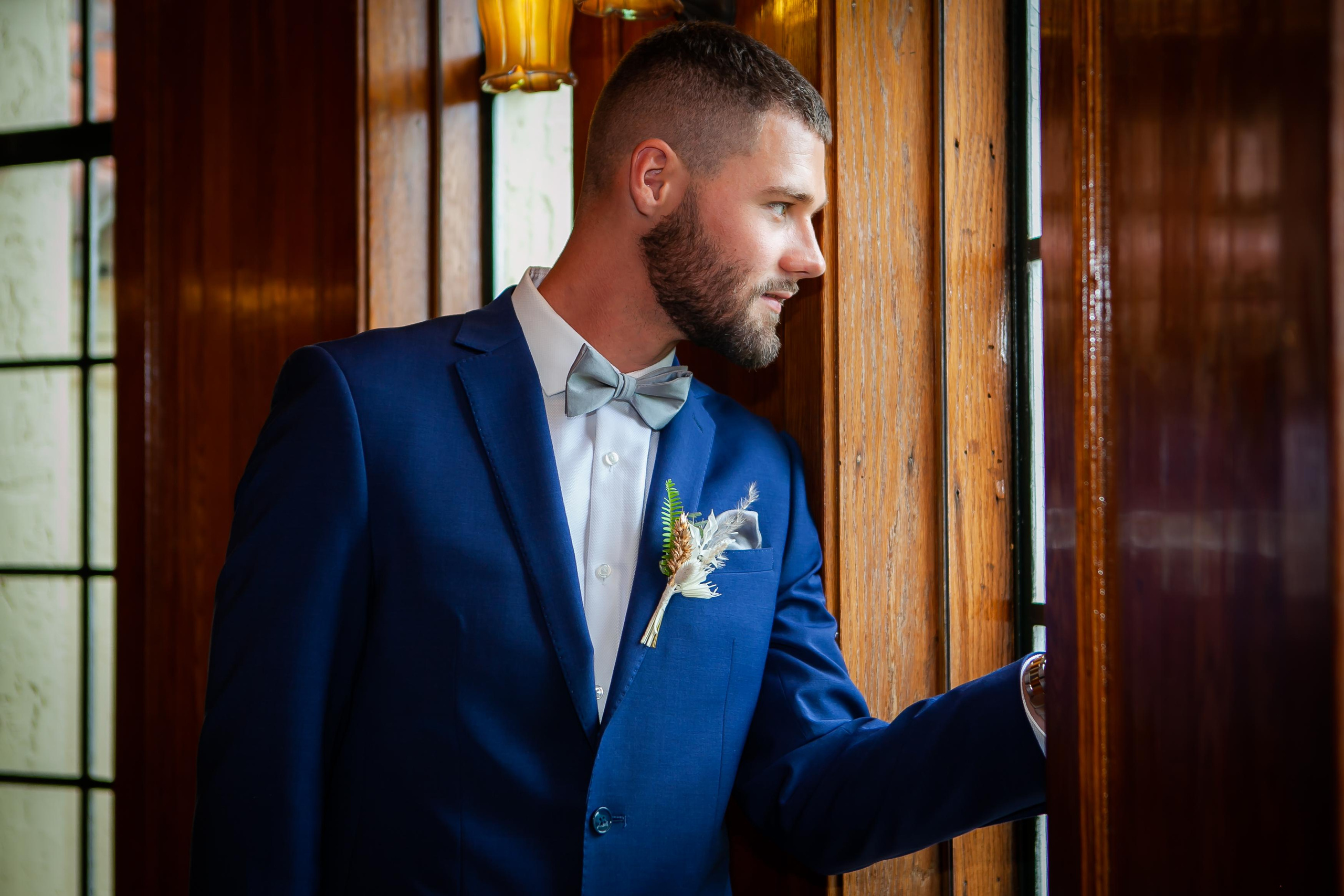 the groom looks thoughtfully out the window