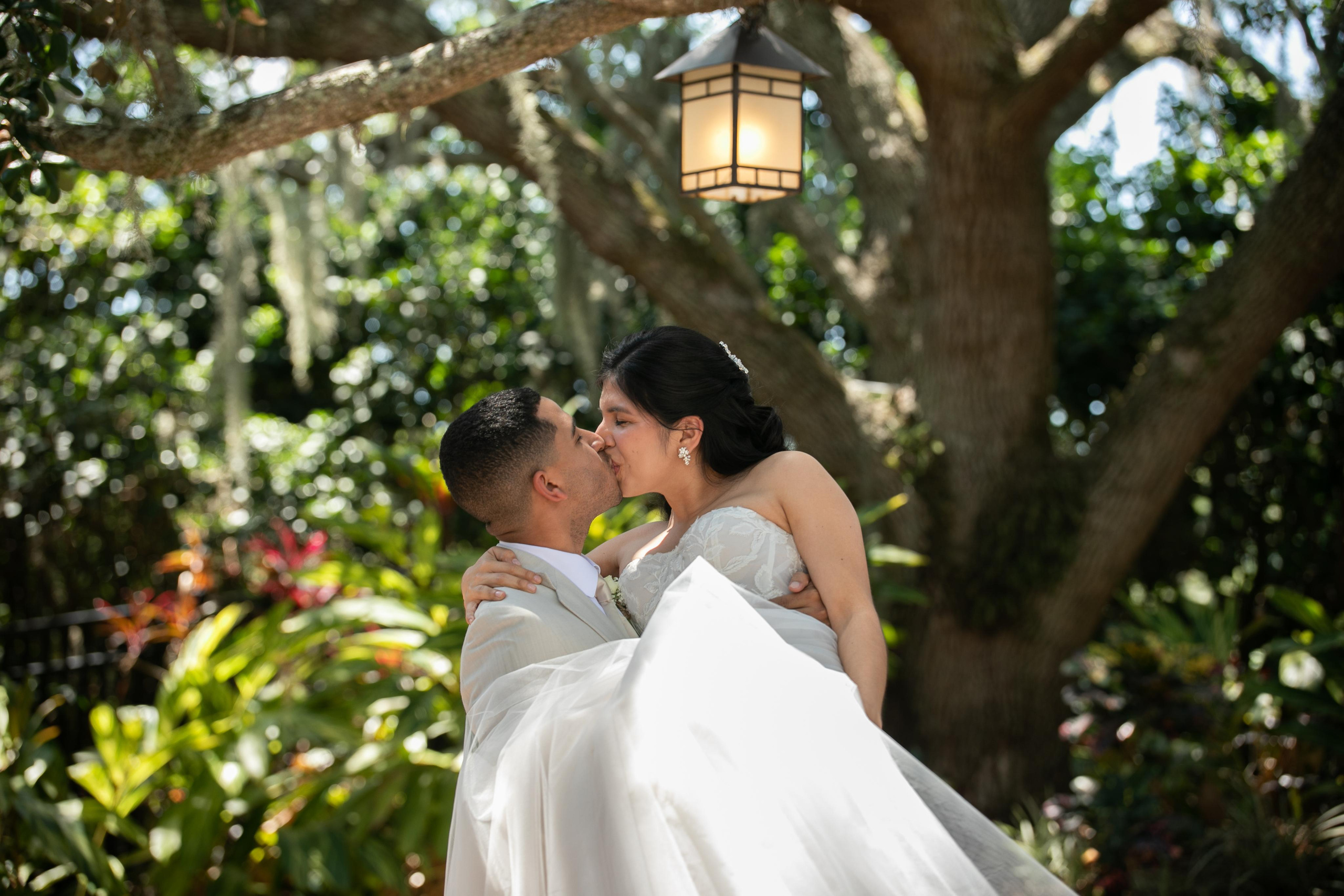 the groom holds the bride in his arms