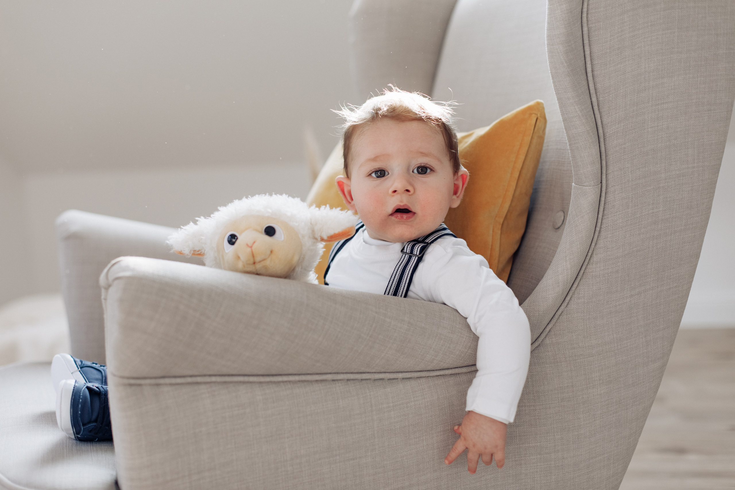 Baby beim Studio-Fotoshooting kuschelt mit seinem Lieblings-Plüschtier – ein herzerwärmender Moment.