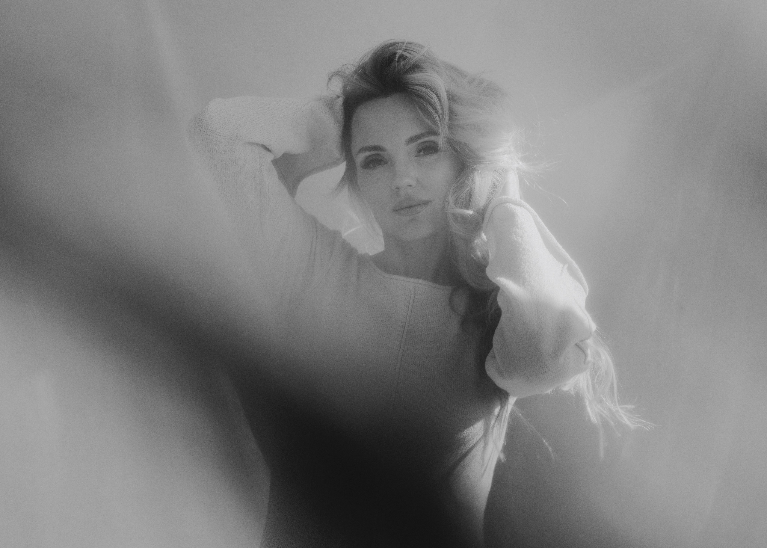Dreamy black and white portrait with soft blurred foreground, natural light and timeless feminine atmosphere. Атмосферный чёрно-белый портрет с мягким размытием на переднем плане, естественным светом и вневременной женственностью.